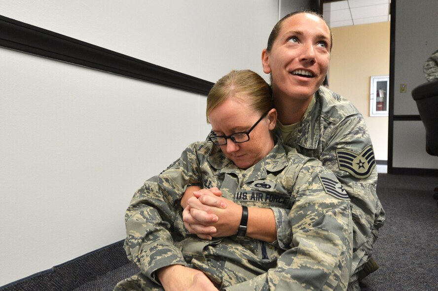 U.S. Air Force Staff Sgt. Elizabeth Dillard, 20th Fighter Wing command post NCO in charge of training, demonstrates a one person cradle drag carry with Tech. Sgt. Paula Hill, 20th FW protocol NCO in charge, during a self-aid and buddy care class at Shaw Air Force Base, S.C., Sept. 3, 2015. During the class, Team Shaw members are taught different ways to properly carry a wounded member depending on their injury. (U.S. Air Force photo by Senior Airman Diana M. Cossaboom/Released)