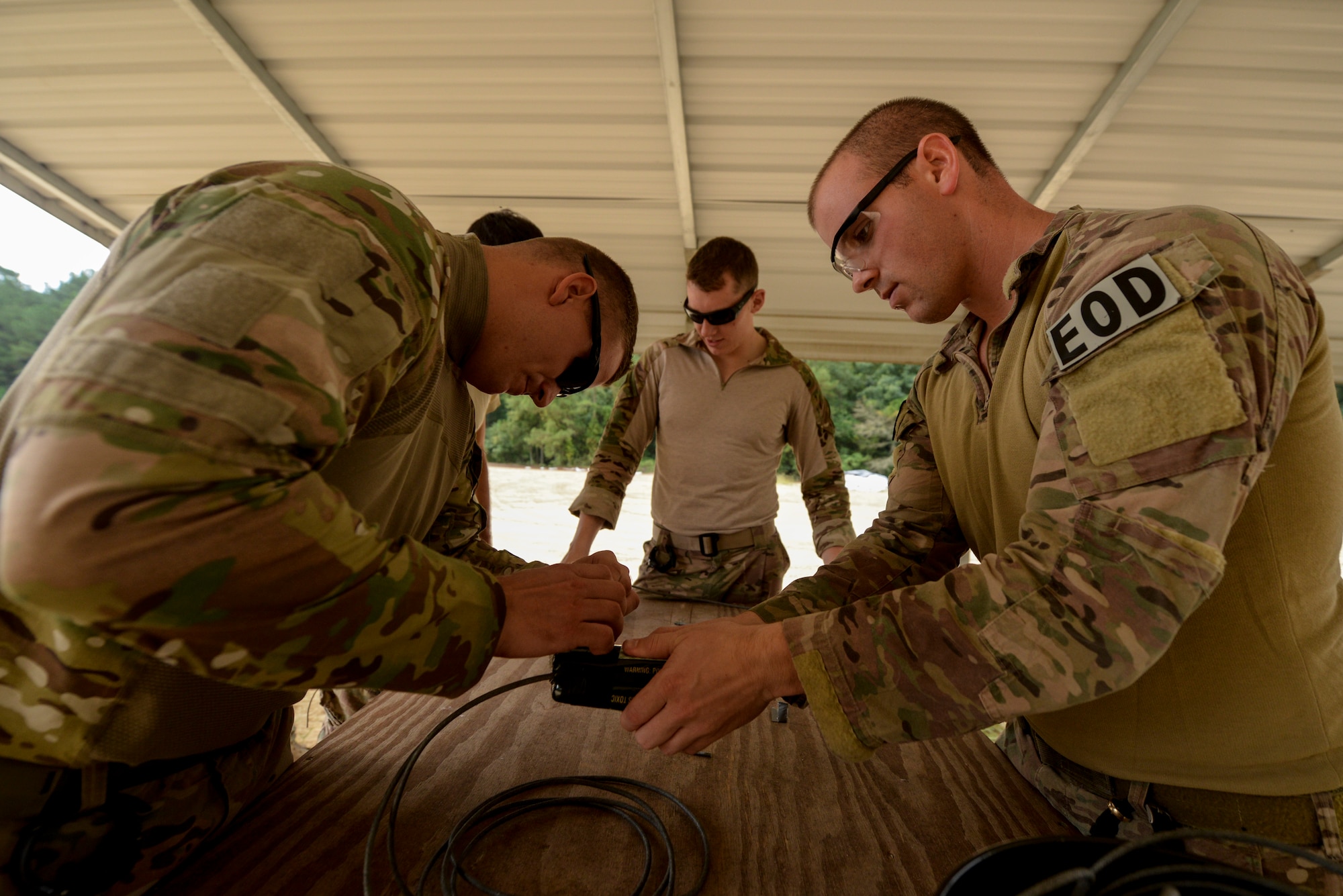 Airmen from the 4th Civil Engineer Squadron explosive ordnance disposal flight work together to assemble a shaped charge as part of Operation Llama Fury, Aug. 26, 2015, at Seymour Johnson Air Force Base, North Carolina. Constructing the charge required EOD Airmen to follow very detailed measurements to ensure proper detonation.  (U.S. Air Force photo/Senior Airman Brittain Crolley)