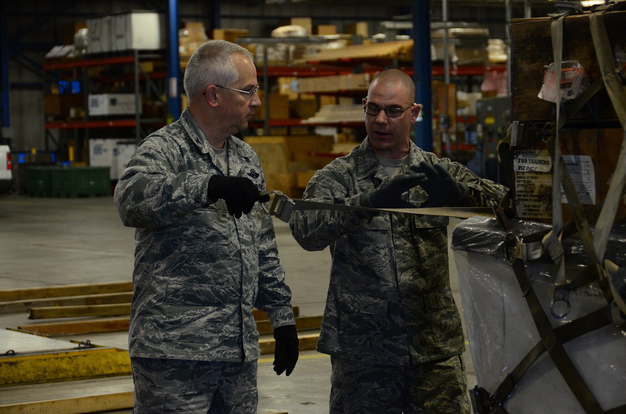 WRIGHT-PATTERSON AIR FORCE BASE, Ohio - Tech. Sgt. Nicholas Garman, 87th Aerial Port Squadron cargo processing flight supervisor, demonstrates to Col. Jeffrey McGalliard, 445th Airlift Wing commander, the proper techniques on securing a pallet load during the Aug. 1, 2015 unit training assembly. McGalliard participated in some of the squadron’s training being conducted during their weekend UTA. (U.S. Air Force photo/Senior Airman Joel McCullough)