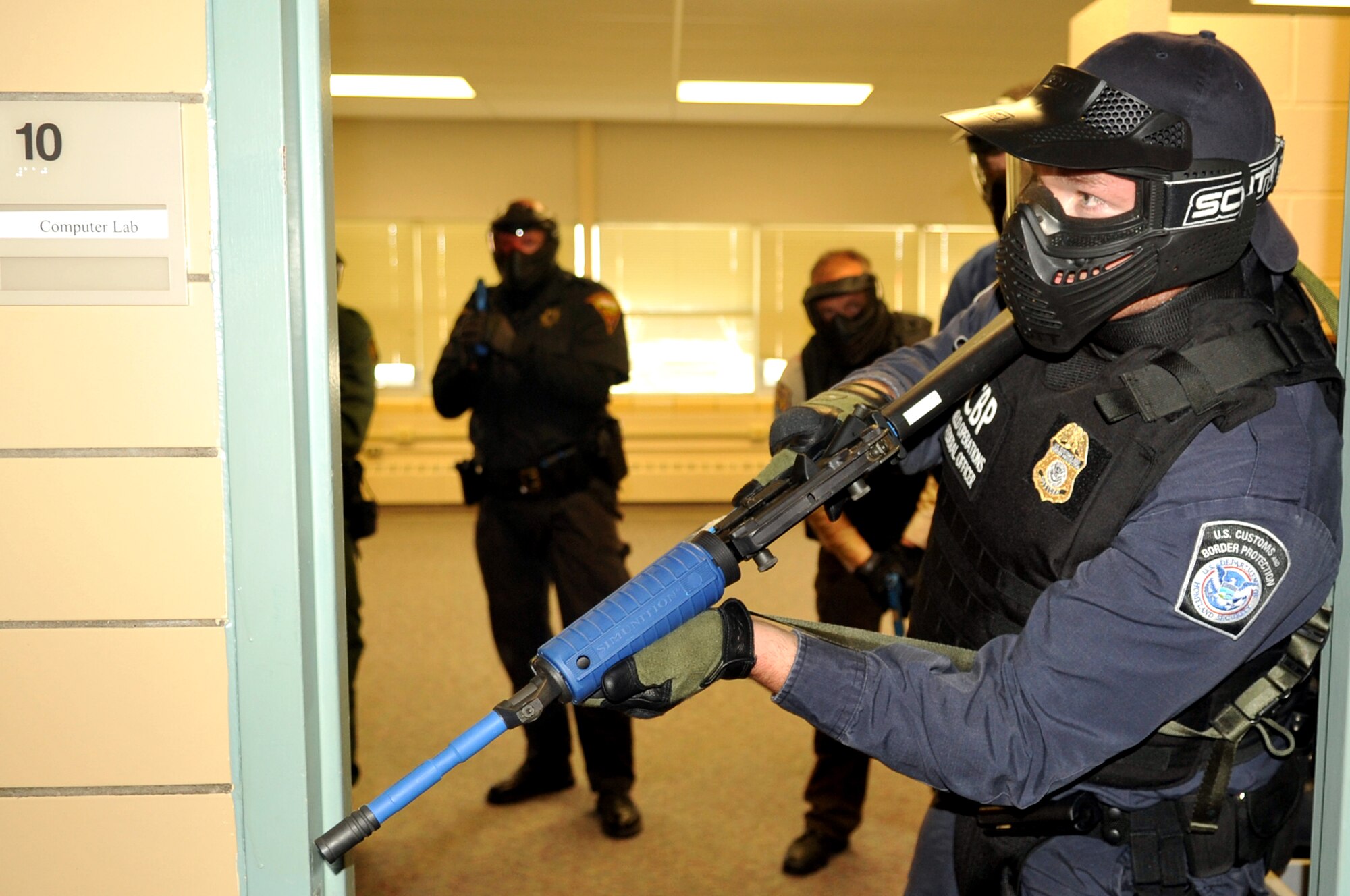 A U.S. Customs and Border Protection officer performs rear security as other police officers practice room clearing procedures during a training scenario Sept. 3, 2015 at Carl Ben Eielson Elementary School on Grand Forks Air Force Base, North Dakota. Nearly two dozen law enforcement officers from various agencies across the region came together here during the first week of September 2015 for some classroom and hands-on training dealing with a variety of active shooter scenarios. (U.S. Air Force photo/Staff Sgt. Susan L. Davis)