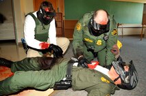 Police officers simulate treating an arterial injury and a sucking chest wound during a training exercise Sept. 3, 2015 at Carl Ben Eielson Elementary School on Grand Forks Air Force Base, North Dakota. Nearly two dozen law enforcement officers from various agencies across the region came together here during the first week of September for some classroom and hands-on training dealing with a variety of active shooter scenarios led by trainers from U.S. Customs and Border Protection. (U.S. Air Force photo/Staff Sgt. Susan L. Davis)