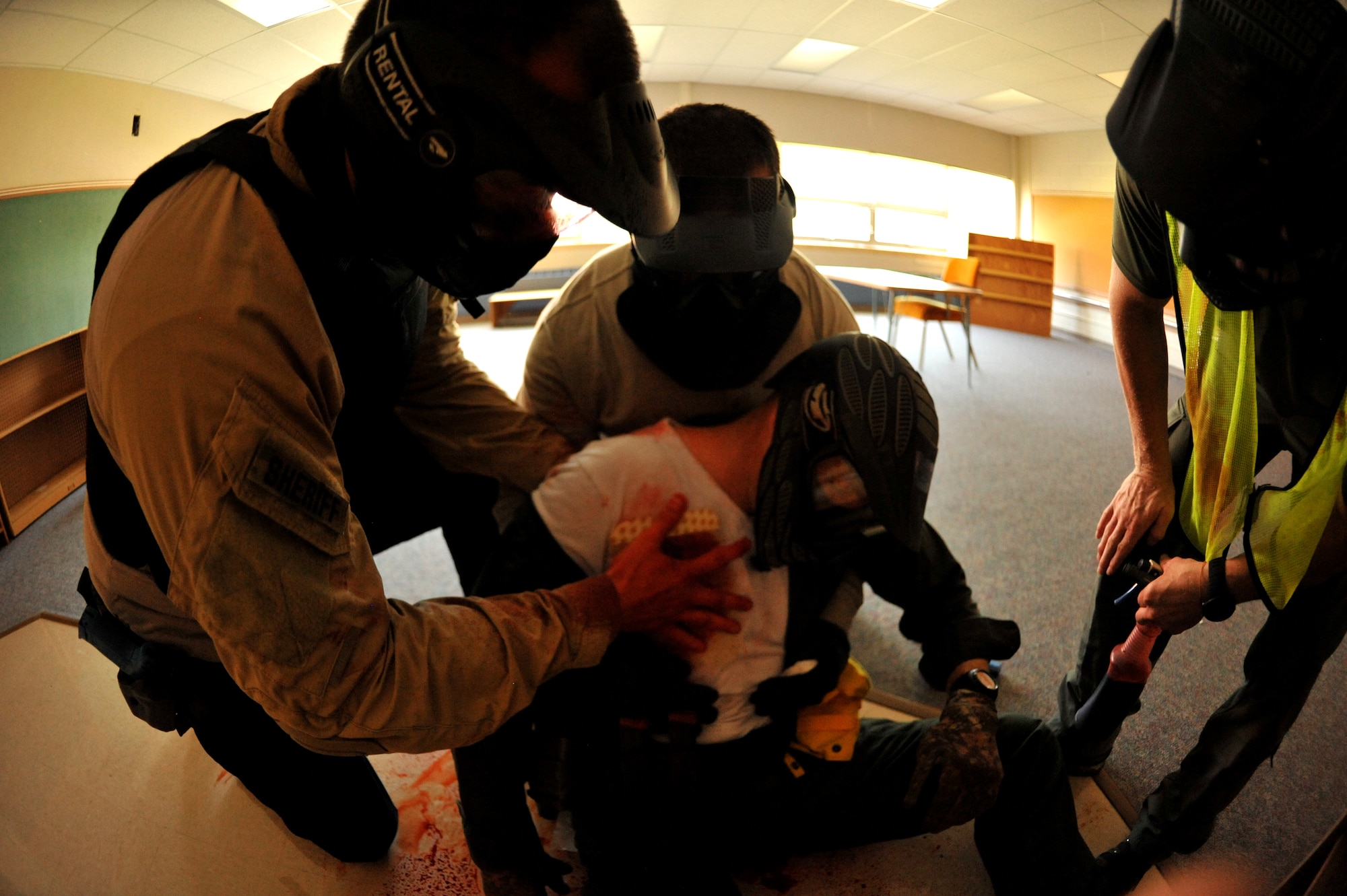 Police officers simulate treating a sucking chest wound during a training exercise Sept. 3, 2015 at Carl Ben Eielson Elementary School on Grand Forks Air Force Base, North Dakota. Nearly two dozen law enforcement officers from various agencies across the region came together here during the first week of September for some classroom and hands-on training dealing with a variety of active shooter scenarios led by trainers from U.S. Customs and Border Protection. (U.S. Air Force photo/Staff Sgt. Susan L. Davis)