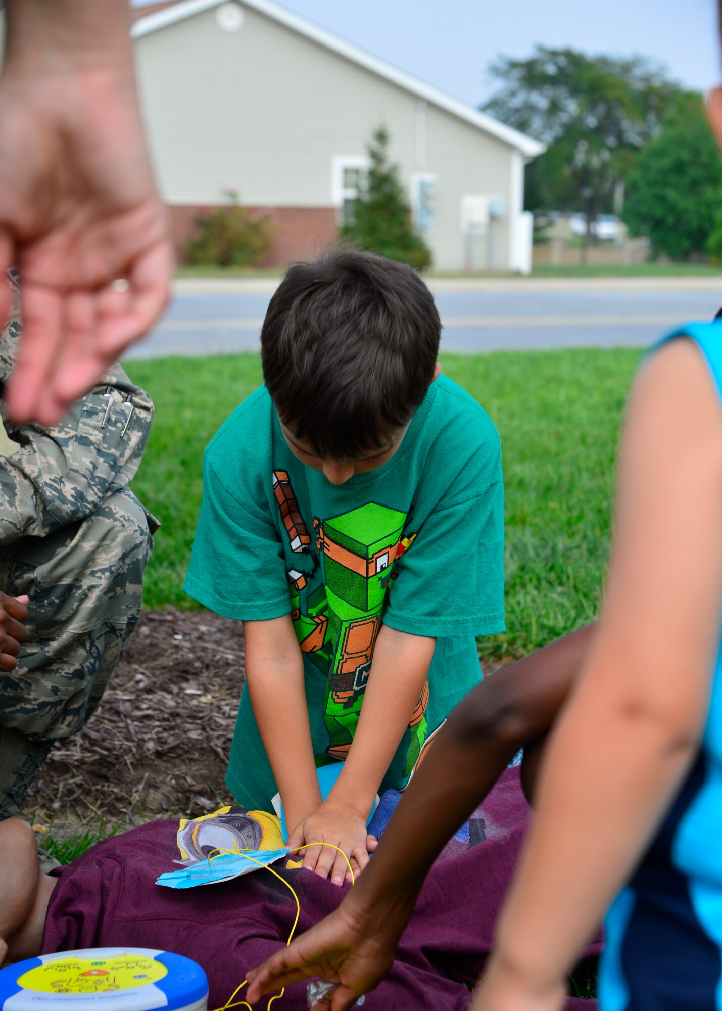 Kyle Struss, son of Staff Sgt. Danielle Struss, Armed Forces Medical Examiner System forensic toxicology technician, performs CPR on a training dummy during the Emergency Management Block Party Sept 3, 2015, on base housing at Dover Air Force Base, Del. September is National Preparedness Month and Team Dover families were able to learn first-aid care from the 436th Medical Operations Squadron at the party. (U.S. Air Force photo/Airman 1st Class William Johnson)