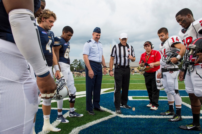 Col. Robert Lyman, Joint Base Charleston commander, participates in the pre-game coin toss with members of the Charleston Southern University and North Greenville University football teams at the CSU football field Sept. 3, 2015, at Charleston, S.C. CSU hosted a military appreciation night during its season opener, where Lyman was the honorary guest to perform the coin toss. CSU beat the North Greenville University Crusaders 41-14. (U.S. Air Force photo/Senior Airman George Goslin) 