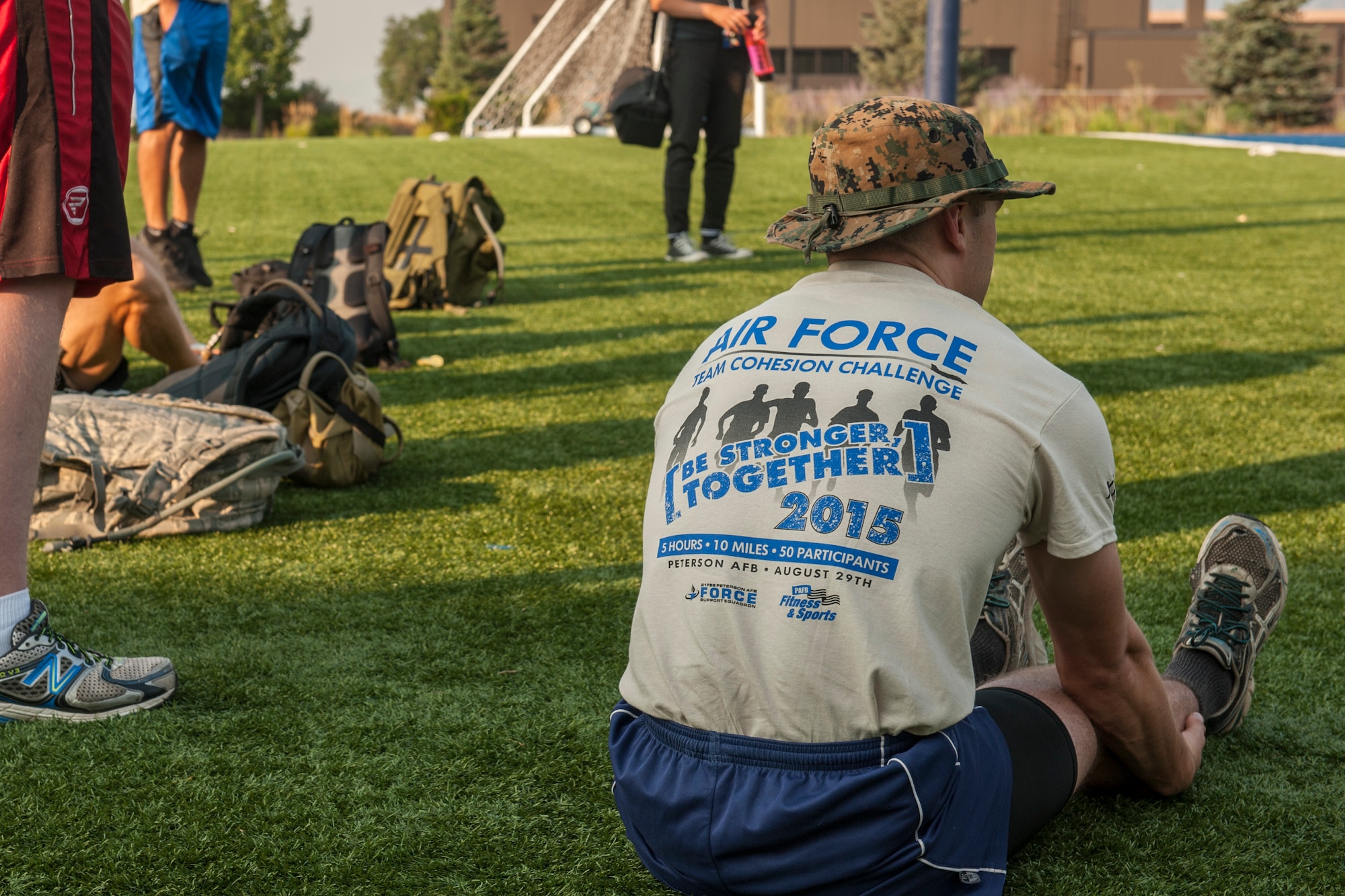 PETERSON AIR FORCE BASE, Colo. – Participants in the Air Force Team Cohesion Challenge stretch and prepare for intense mental and physical tasks behind the base Fitness Center, Aug. 29, 2015. The challenge required participants to load a rucksack with weight and compete in roughly five hours of team building events that covered a distance of seven to ten miles. Each task given wasn’t something that could be completed on their own, so participants had to become a solid team and work together. (U.S. Air Force photo by Airman 1st Class Rose Gudex)
