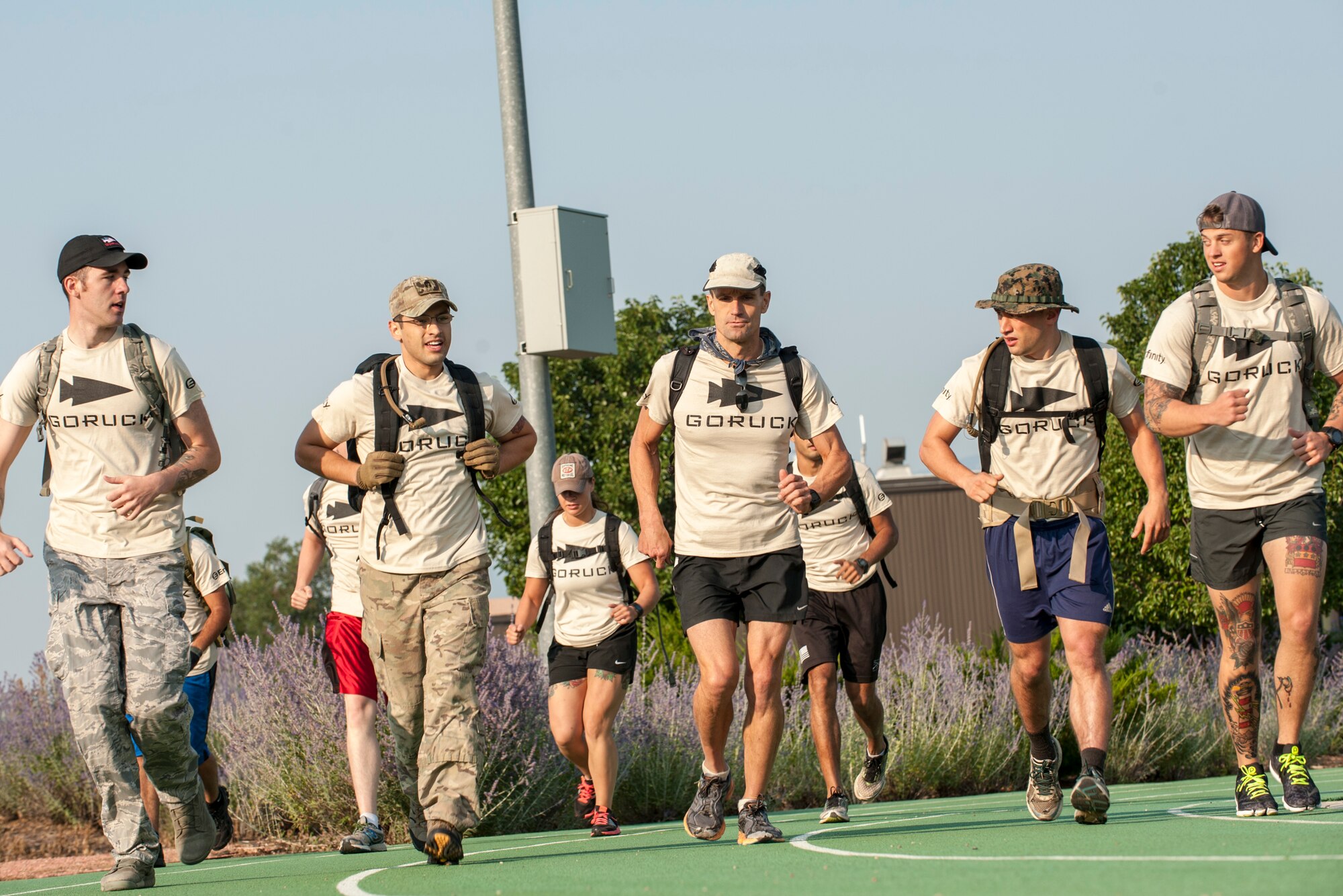 PETERSON AIR FORCE BASE, Colo. – Participants in the Air Force Team Cohesion Challenge run around the track between challenges behind the base Fitness Center, Aug. 29, 2015. The challenge required participants to load a rucksack with weight and compete in five hours of team building events that covered a distance of seven to ten miles. Each task given wasn’t something that could be completed on their own, so participants had to become a solid team and work together. (U.S. Air Force photo by Airman 1st Class Rose Gudex)