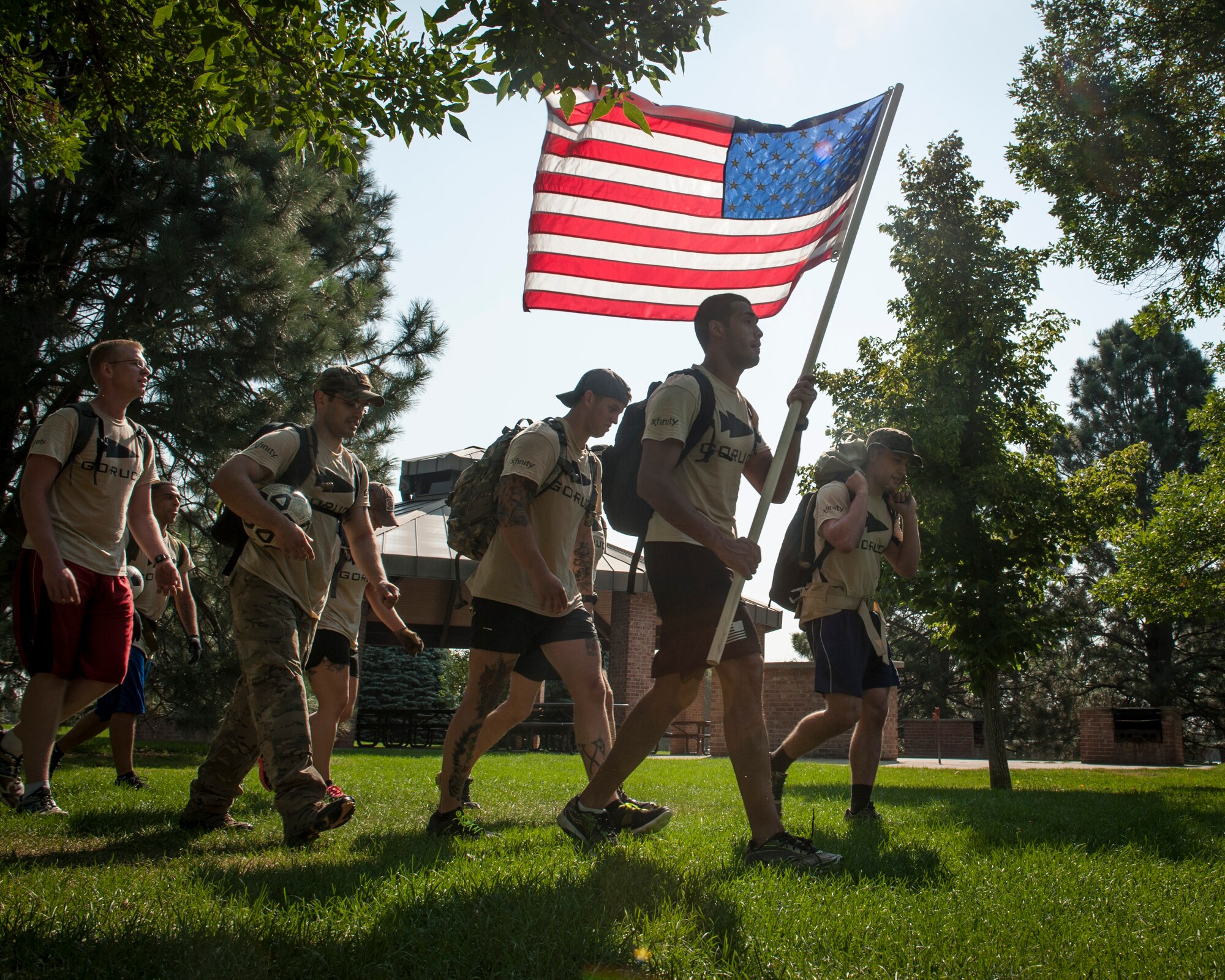 PETERSON AIR FORCE BASE, Colo. – Peterson Airmen carry the American flag high as they ruck across base in the Team Cohesion Challenge, which started at the Fitness Center here, Aug. 29, 2015. The challenge brought Airmen together to build teamwork and camaraderie in tasks that could not be completed alone. After doing callisthenic-like exercises for two hours, they spent three more hours rucking around base and completing challenges together. This is the first time TCC came to Peterson and will be back next year. (U.S. Air Force photo by Airman 1st Class Rose Gudex)