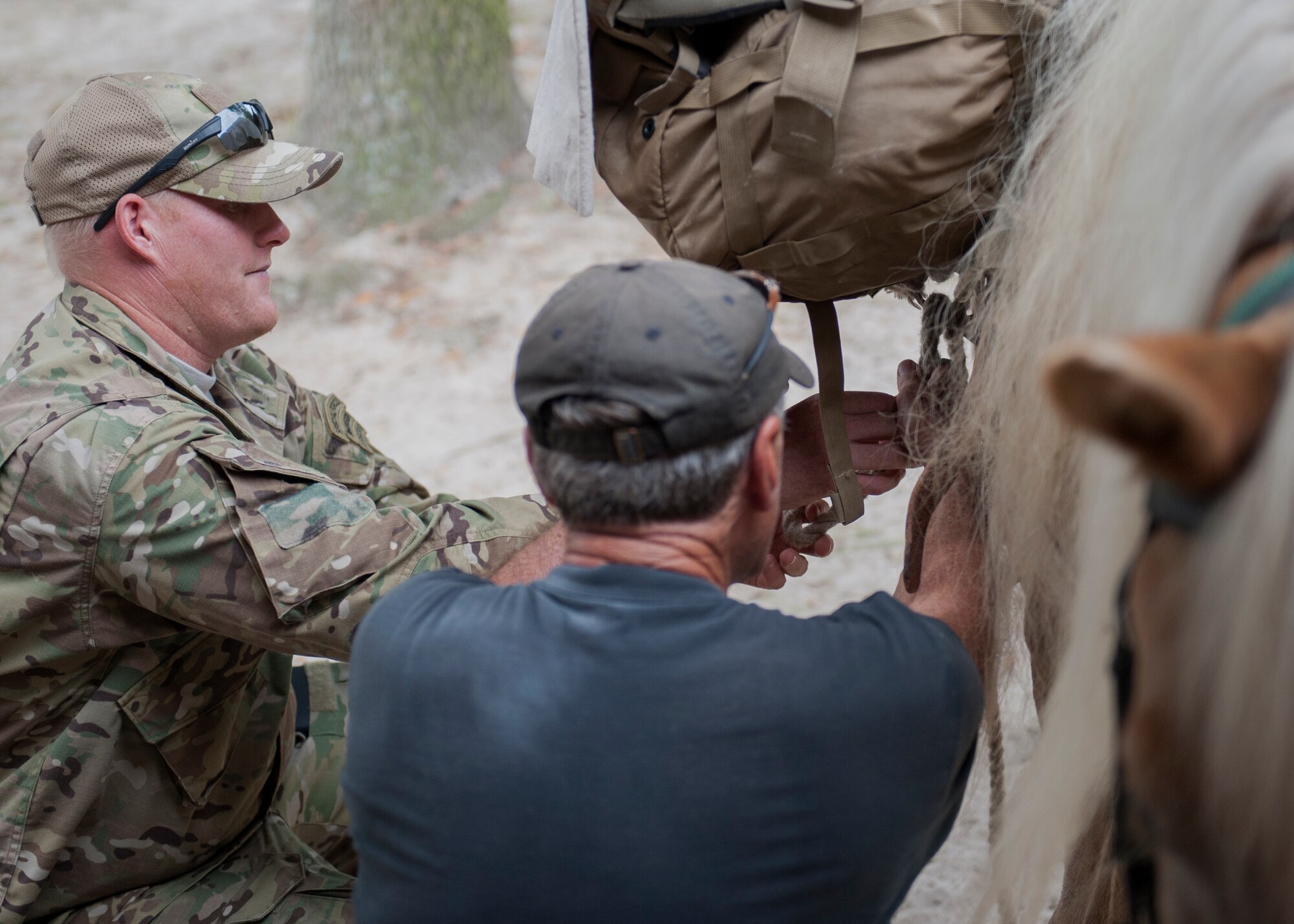 Charlie Brown, teaches a Soldier with the Army’s 7th Special Forces Group (Airborne), how to secure gear on a horse at Eglin Air Force Base, Fla. Sept. 3. Members of Eglin’s Sand and Spur Riding Club provide volunteers and horses to train service members how to saddle, pack, ride and care for horses. The training is done to expose them to horses and to teach techniques they can apply when deployed to remote locations. (U.S. Air Force photo/Ilka Cole) 