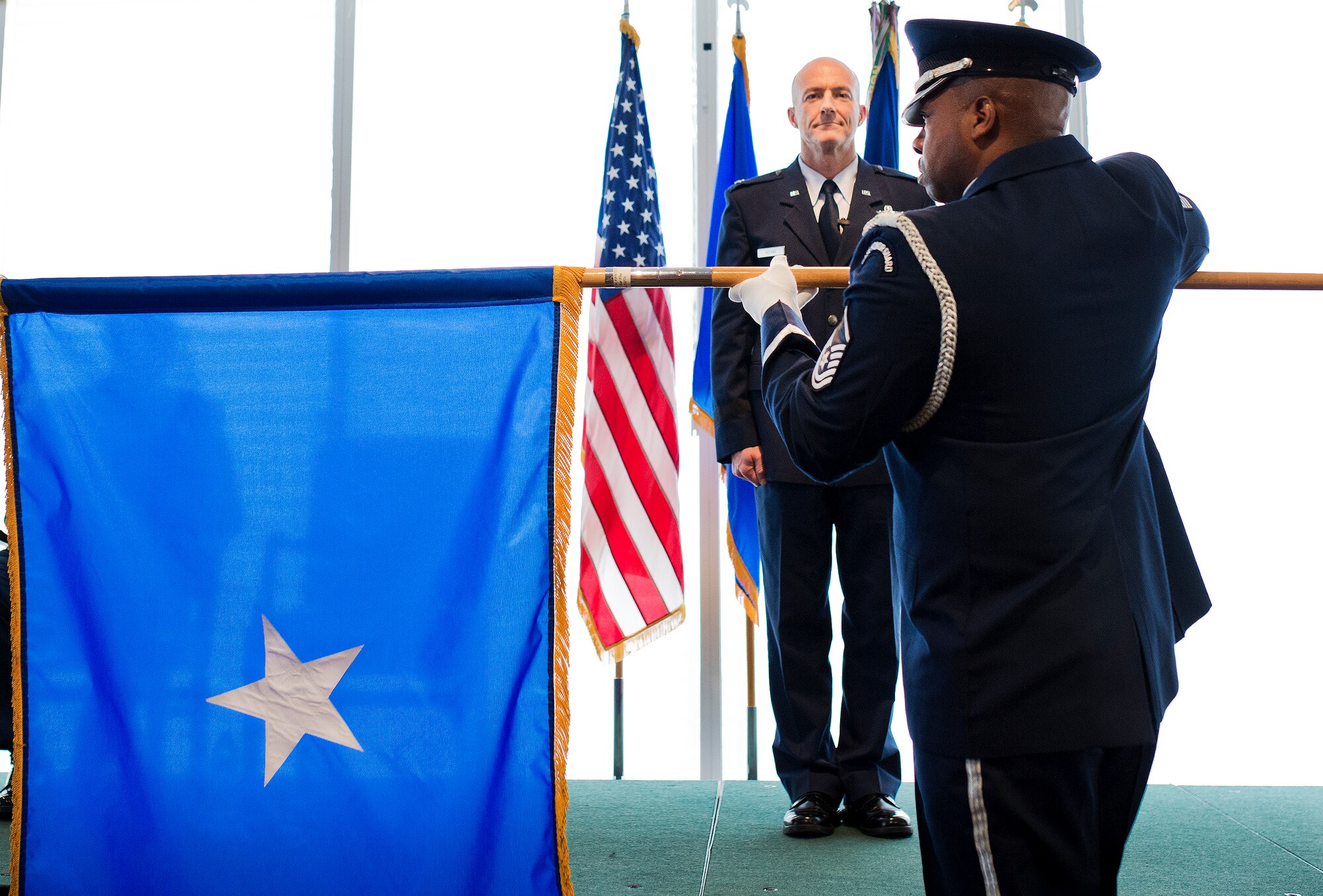 Brig. Gen. Christopher Azzano, the 96th Test Wing commander, stands at attention as his new one-star flag is unfurled during his promotion ceremony Sept. 2 at Eglin Air Force Base, Fla. (U.S. Air Force photo/Samuel King Jr.)