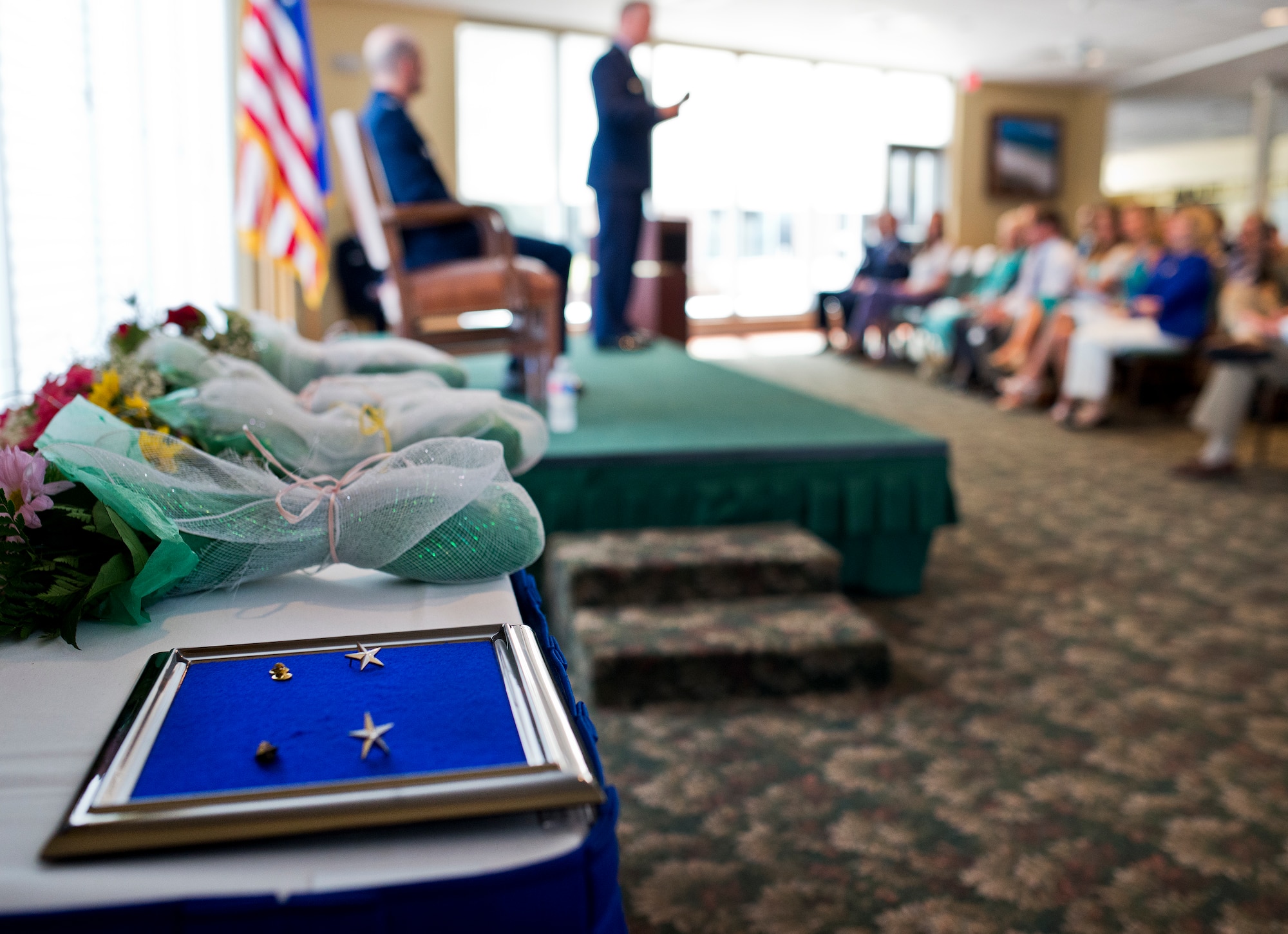 Two star pins await Col. Christopher Azzano’s (seated) new promotion to brigadier general during a ceremony Sept. 2 at Eglin Air Force Base, Fla.  Maj. Gen. David Harris (standing), the Air Force Test Center commander, officiated the promotion ceremony for Azzano. (U.S. Air Force photo/Samuel King Jr.)