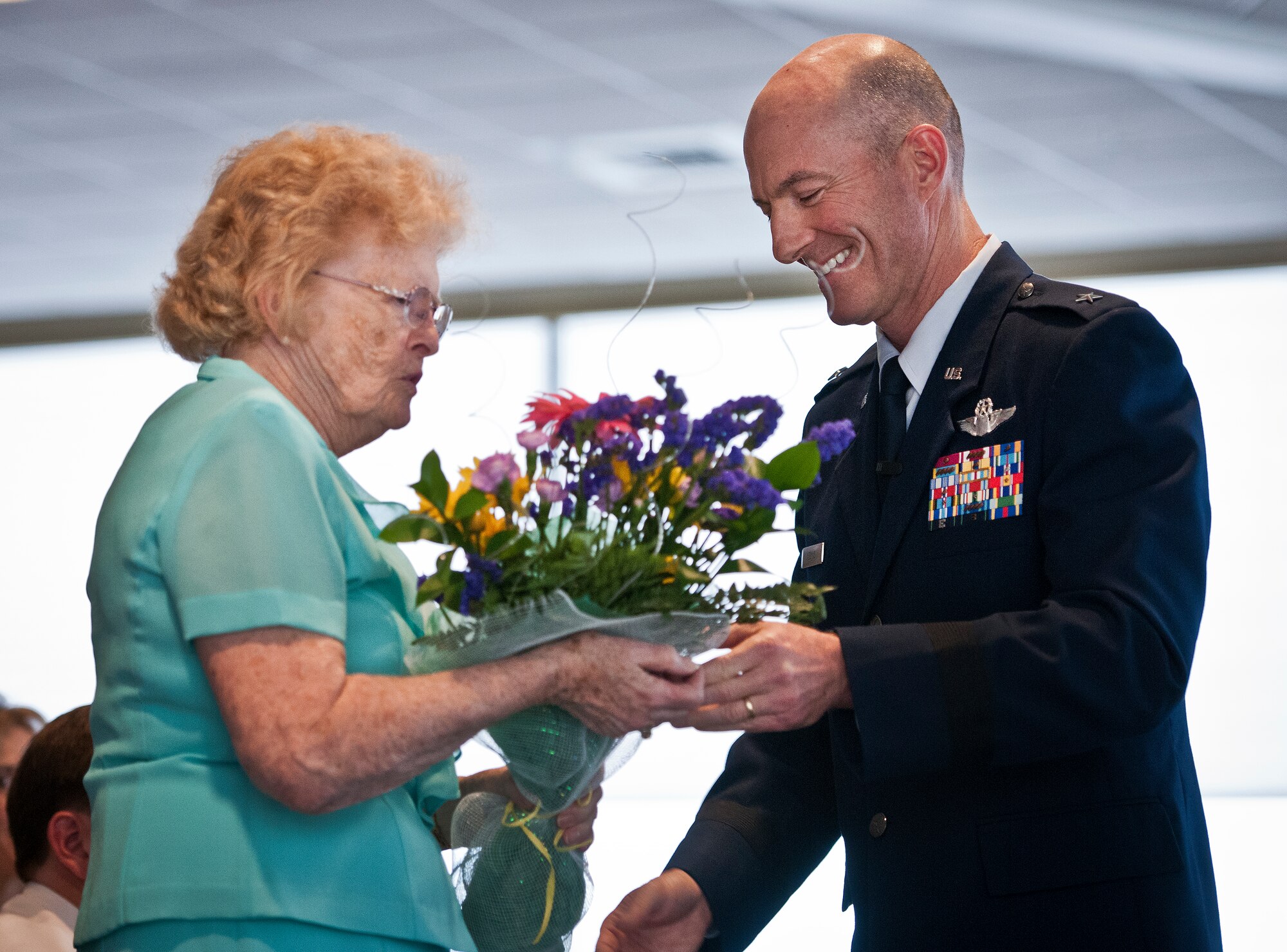Brig. Gen. Christopher Azzano, the 96th Test Wing commander, presents a boutique of flowers to his mother, Judy, during his promotion ceremony Sept. 2 at Eglin Air Force Base, Fla.  During the ceremony, his family removed the eagle ranks and pinned on his new stars. (U.S. Air Force photo/Samuel King Jr.)