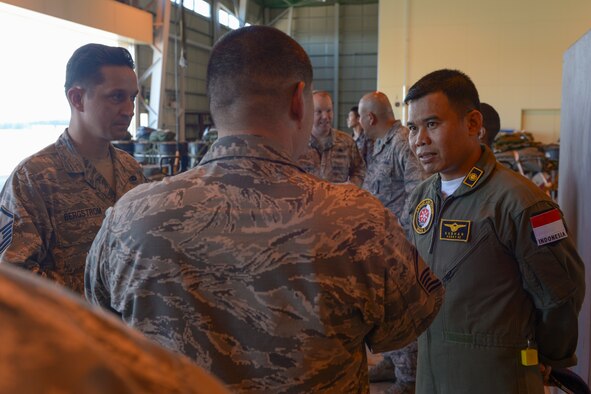 A member of the Indonesian Air Force chats with US Air Force Airmen during the 2015 Pacific Agility Logistics and Safety Symposium at Yokota Air Base, Japan, Sept. 2, 2015. The symposium is a Pacific Command initiative aimed at increasing interoperability between regional partners. It allowed the multinational participants to discuss and learn innovative safety, supply and maintenance standards. (U.S. Air Force photo by Staff Sgt. Cody H. Ramirez/Released)