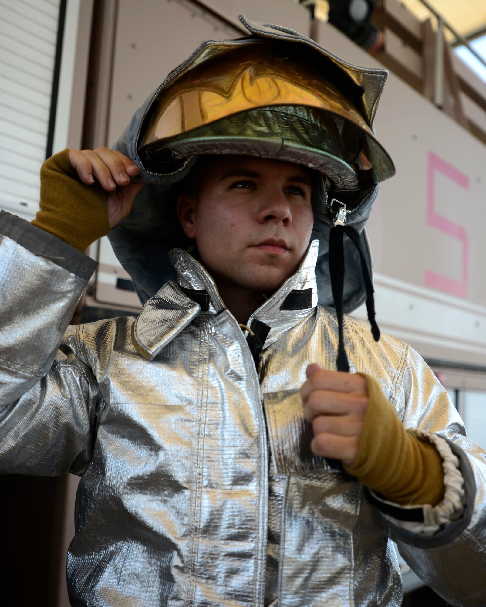 U.S. Air Force Senior Airman Zach White, 332nd Expeditionary Civil Engineer Squadron fire truck engineer and driver operator, dons his helmet at an undisclosed location in Southwest Asia, Aug. 20, 2015. White spends his off-time logging miles to raise awareness for the Special Olympics. (U.S. Air Force photo by Senior Airman Racheal E. Watson/Released) 