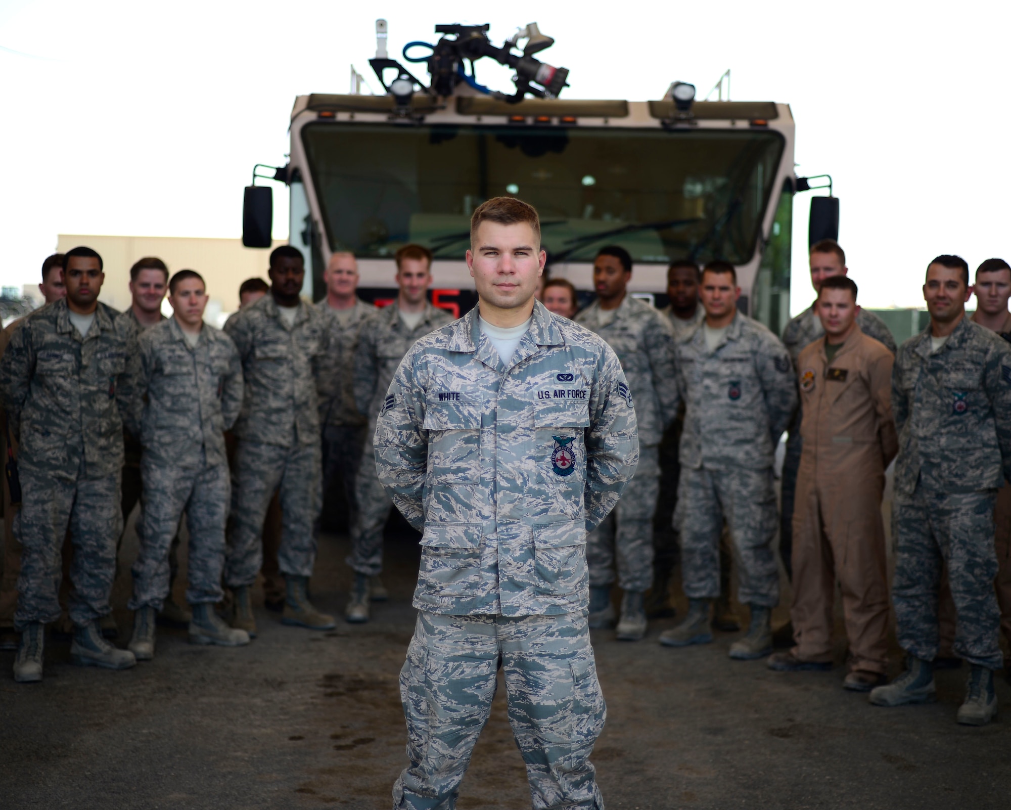 U.S. Air Force Senior Airman Zach White, 332nd Expeditionary Civil Engineer Squadron fire truck engineer and driver operator, stands in front of his fire fighter comrades at an undisclosed location in Southwest Asia, Aug. 20, 2015. White dedicated his spare time during his deployment by running 150 miles to raise $2,500 to sponsor an athlete for the 2017 Special Olympics. (U.S. Air Force photo by Senior Airman Racheal E. Watson/Released)