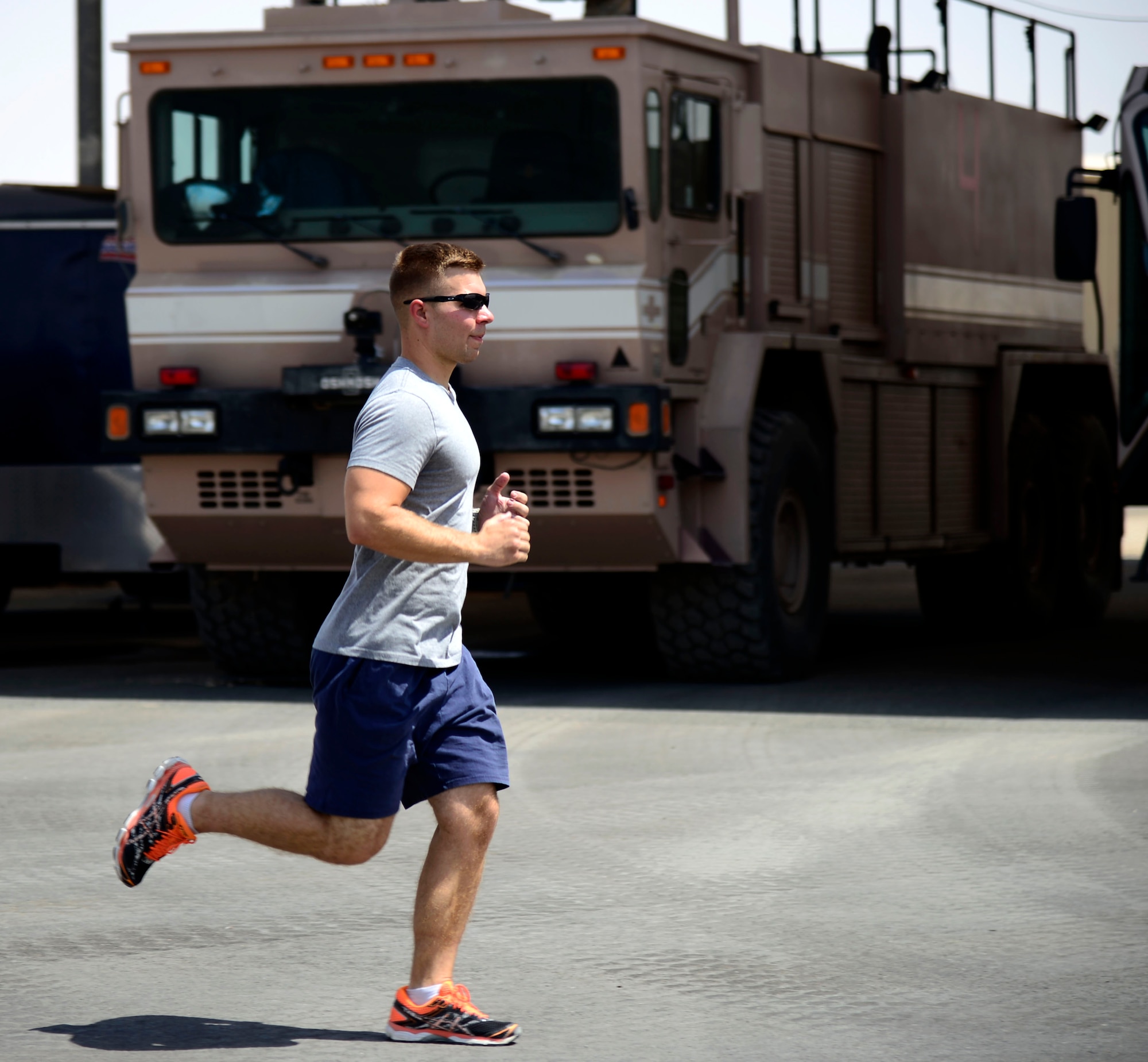 U.S. Air Force Senior Airman Zach White, 332nd Expeditionary Civil Engineer Squadron fire truck engineer and driver operator, runs to raise awareness for the Special Olympics at an undisclosed location in Southwest Asia, Aug. 20, 2015. White faces challenges such as temperatures more than 120 degrees and a tasking deployment schedule, but makes every mile count. (U.S. Air Force photo by Senior Airman Racheal E. Watson/Released)