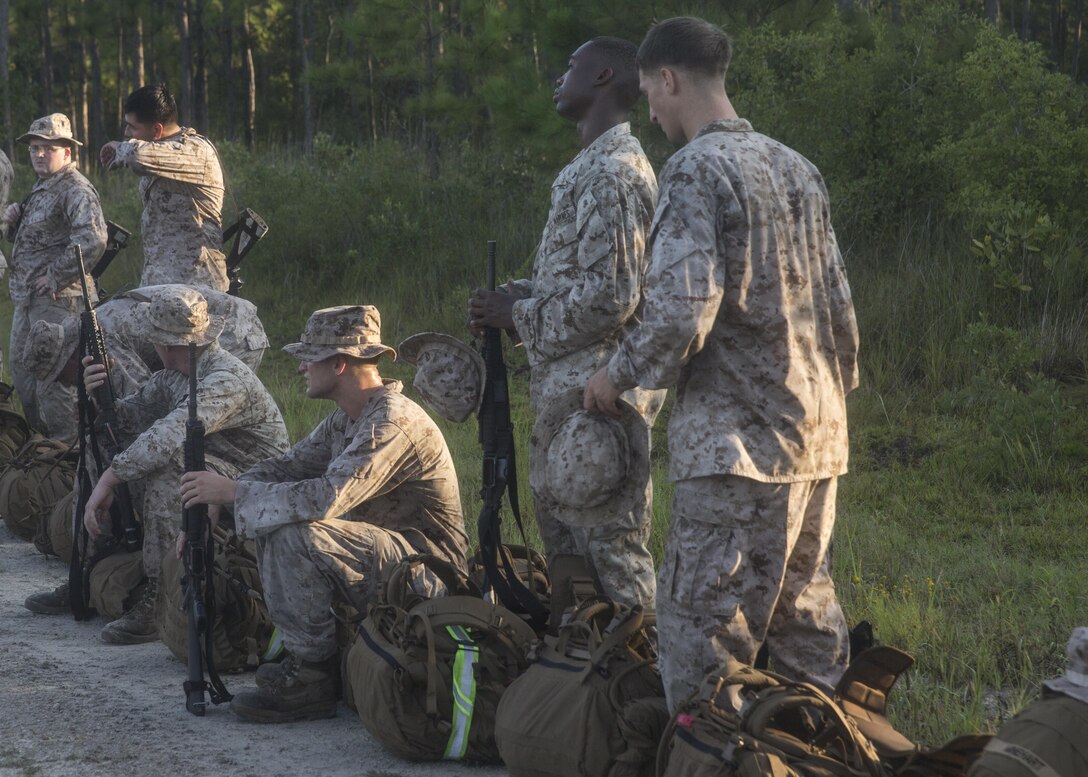 Marines with Headquarters Company, Combat Logistics Regiment 2, relax after completing a conditioning hike aboard Camp Lejeune, N.C., Sept. 2, 2015. The Marines conducted the six–mile hike, which started and ended at Landing Zone Egret, while carrying packs and weapons to condition their bodies for more strenuous hikes in the future. (U.S. Marine Corps photo by Lance Cpl. Aaron Fiala/Released)