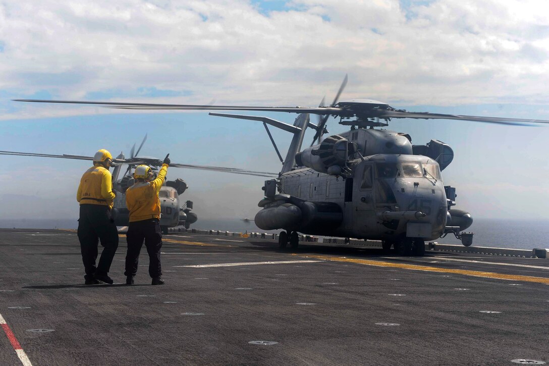Navy Petty Officer 3rd Class Paula Becerril signals to a CH-53E Super Stallion helicopter on the flight deck of the amphibious assault ship USS Boxer during Dawn Blitz 2015 in the Pacific Ocean, Sept. 6, 2015. Becerril is an aviation boatswain’s mate (handling). The Super Stallion is attached to Marine Heavy Helicopter Squadron 465. U.S. Navy photo by Petty Officer 2nd Class Jose Jaen