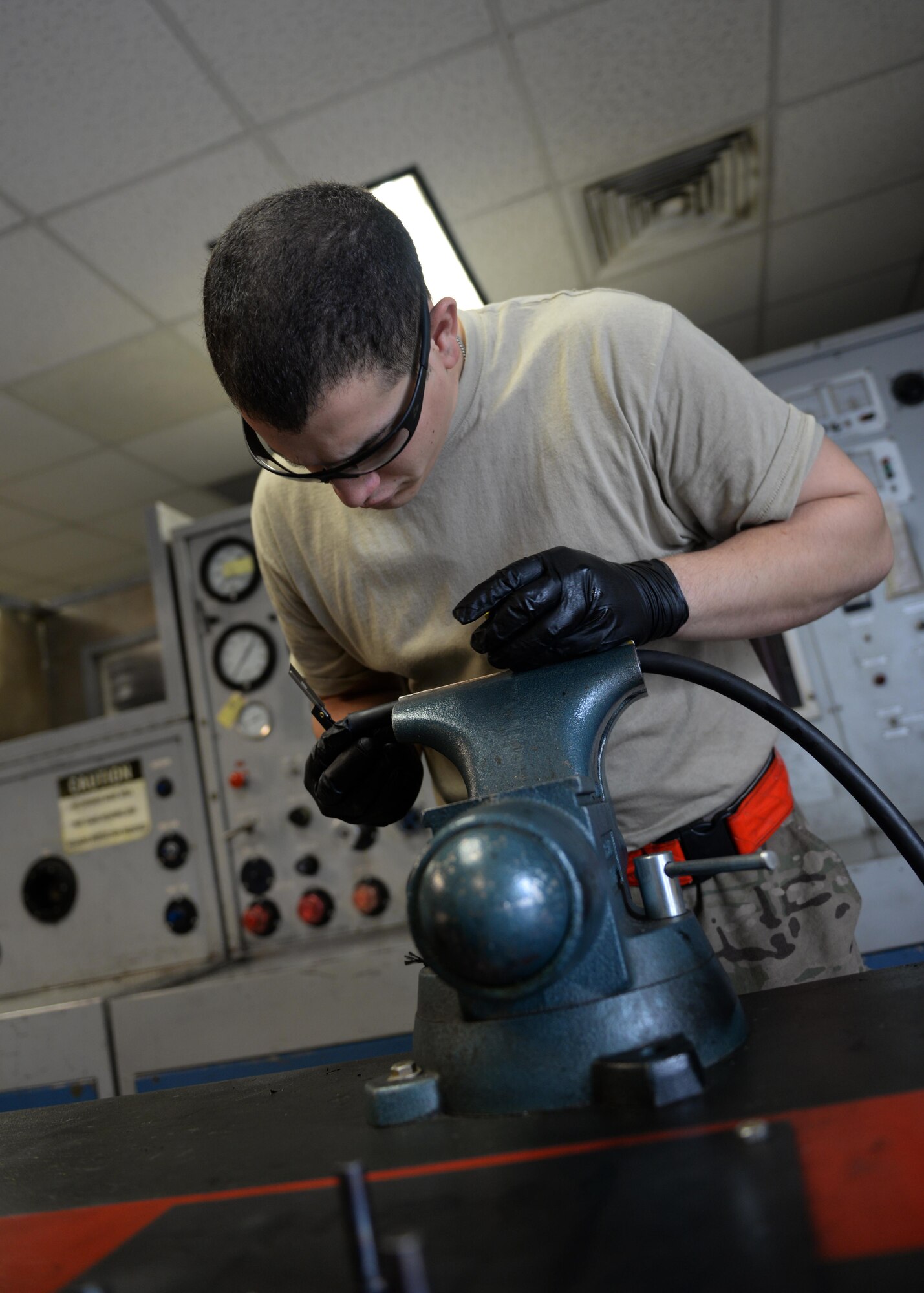 U.S. Air Force Staff Sgt. Jesus Rodriguez-Cruz, 555th Expeditionary Fighter Squadron aircraft hydraulics specialist, cuts a hose to be put on a hydraulics system in an F-16 Fighting Falcon aircraft Sept. 7, 2015, at Bagram Airfield, Afghanistan. Rodriguez-Cruz is responsible for repairing the hydraulics parts from the landing gear for the F-16. (U.S. Air Force photo by Senior Airman Cierra Presentado/Released)