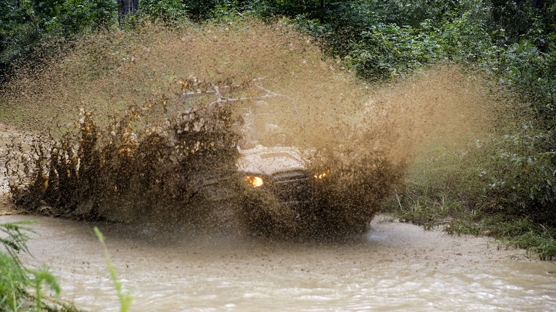 A Marine with Alpha Company, 2nd Reconnaissance Battalion drives and splashes a Polaris Razor through a mud-hole in the woods during a basic recreational off-highway vehicle training qualification course on Camp Lejeune, N.C., Sept. 1, 2015.  The course is designed to introduce Marines to the two-seater all-terrain vehicle, and familiarize them to its capabilities and safety consideration.  (U.S. Marine Corps photo by Cpl. Alexander Mitchell/released)