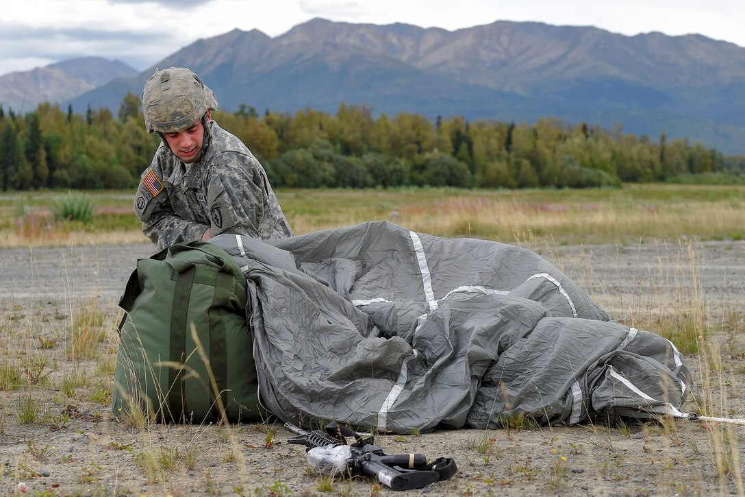 Army Sgt. Kyle Hauck recovers his parachute after conducting a practice jump during Pacific Airlift Rally 2015 on Malemute drop zone, Joint Base Elmendorf-Richardson, Alaska, Aug. 27, 2015. Hauck is assigned to the 25th Infantry Division's Company H, 3rd Battalion, 509th Infantry Regiment, 4th Infantry Brigade Combat Team, Alaska. U.S. Air Force photo by Alejandro Pena 