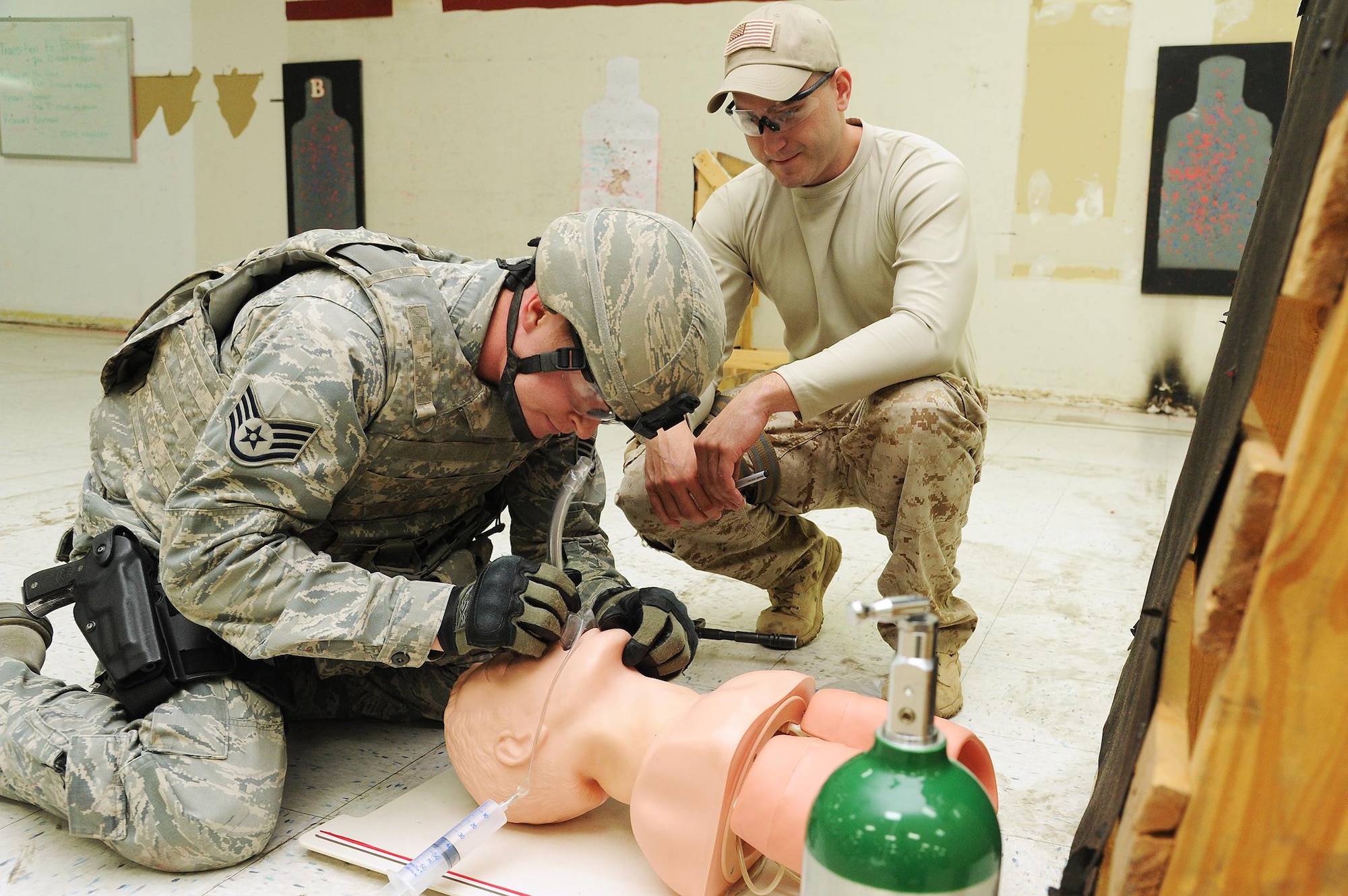 Staff Sgt. Derek Ables (left), 21st Security Forces Squadron, establishes an airway on a simulated patient using a nasopharyngeal tool during a pilot course for Tactical Combat Casualty Care on Aug. 7, 2015 at Peterson Air Force Base, Colo. Tech. Sgt. Bradley Belcher, 302nd Aeromedical Staging Squadron, instructed the T-CCC beta course for non-medical personnel in order to help eliminate preventative deaths on the battlefield. (U.S. Air Force photo/Senior Airman Amber Sorsek)