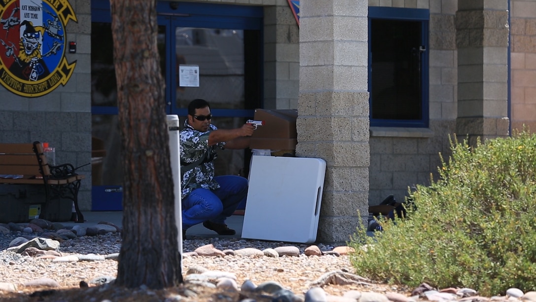 An active shooter response exercise participant simulates firing a handgun during an active shooter response exercise aboard Marine Corps Air Station Miramar, California, Sept. 2. The station also participated in an aircraft mishap response exercise the next day as part of required annual safety training for the installation.