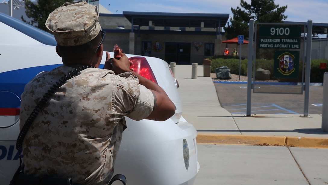 Cpl. Desean White, a military police officer stationed with the Provost Marshal’s Office, posts behind his vehicle during an active shooter response exercise aboard Marine Corps Air Station Miramar, California, Sept. 2. Military and civilian police worked together during the exercise as part of required annual safety training.