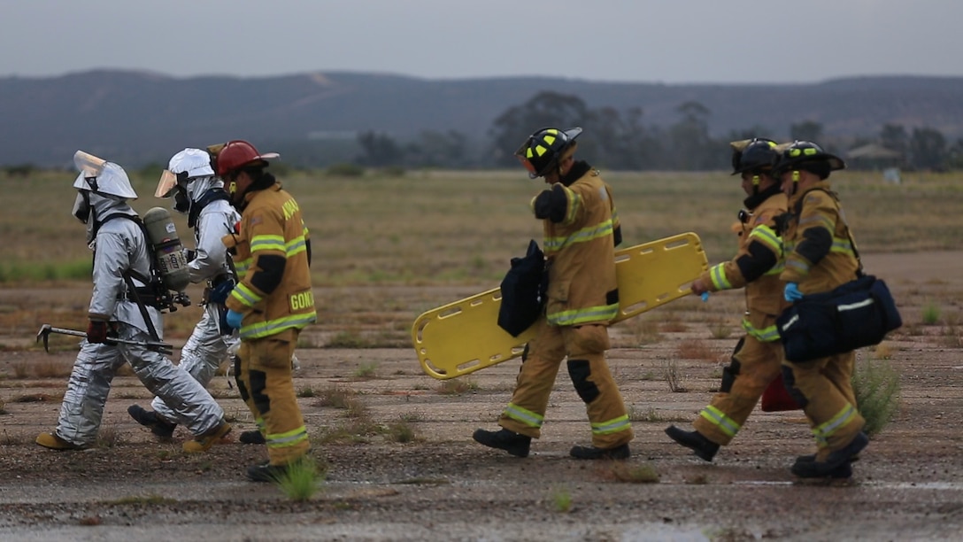 Marines with Aircraft Rescue and Firefighting and base firefighters stationed at Marine Corps Air Station Miramar, California, check a simulated crash site for victims during an aircraft mishap response exercise aboard the air station, Sept. 3. The aircraft mishap response included two simulated crashes where responding personnel had to extinguish any fires and locate and assist crash victims.