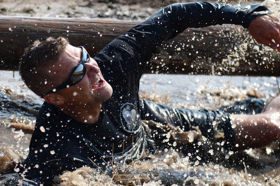 Air Force Chief Master Sgt. Wayne Stott splashes through muddy water during the second annual mud run at F.E. Warren Air Force Base in Wyoming, Aug. 29, 2015. The run attracted more than 100 airmen and their families. Stott is the 90th Medical Group superintendent. U.S. Air Force photo by Airman 1st Class Brandon Valle