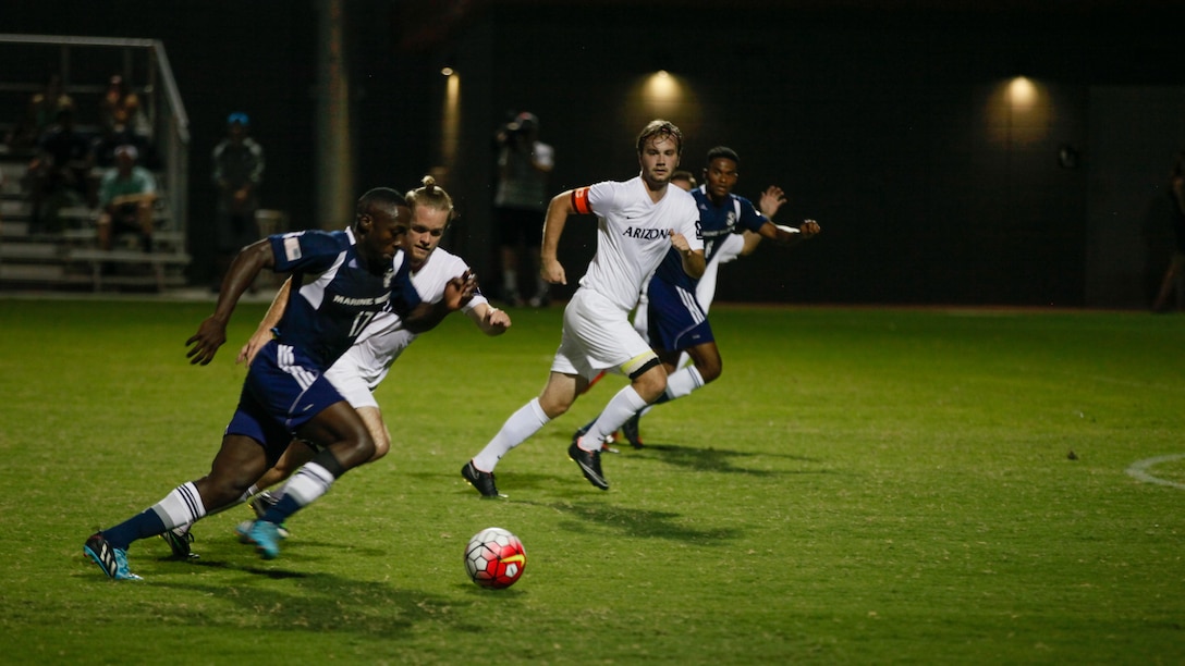 The All-Marine soccer team pushes forward while University of Arizona Men’s soccer club tries to regain possession during the first half of the exhibition match at Tucson, Arizona, Sept. 9, 2015.  The University of Arizona won the game 2-1 with a goal scored near the end of the second half.