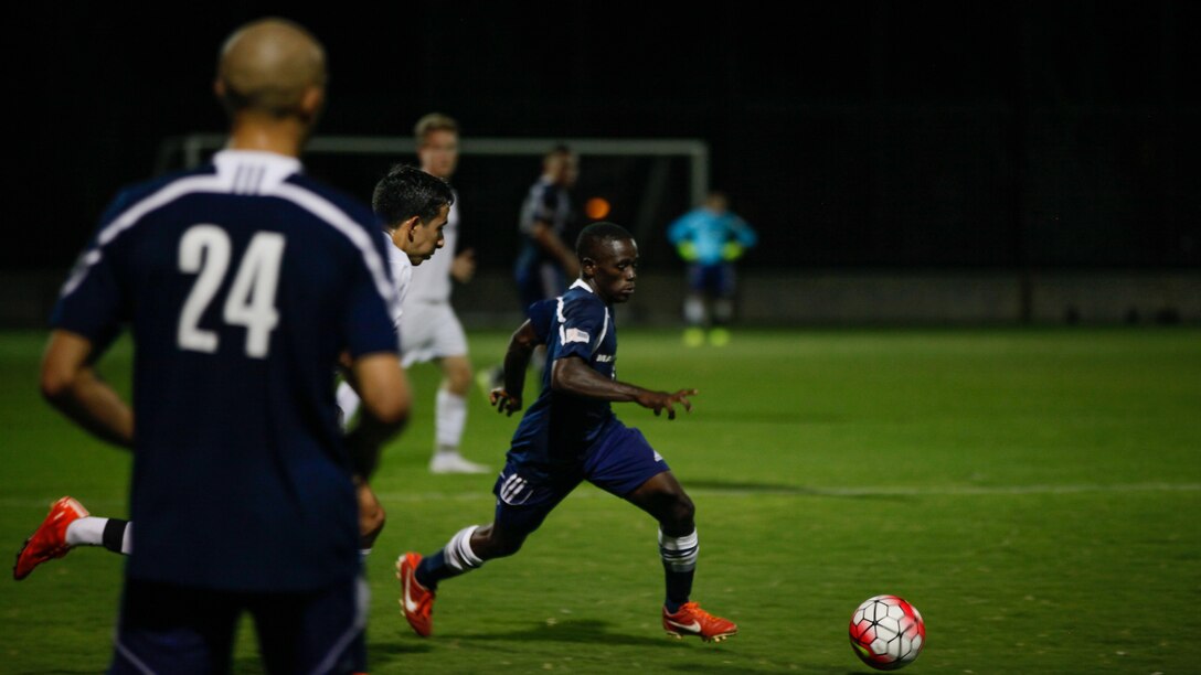 The All-Marine soccer team pushes forward while University of Arizona Men’s soccer club tries to regain possession during the first half of the exhibition match at Tucson, Arizona, Sept. 9, 2015.  The University of Arizona won the game 2-1 with a goal scored near the end of the second half.