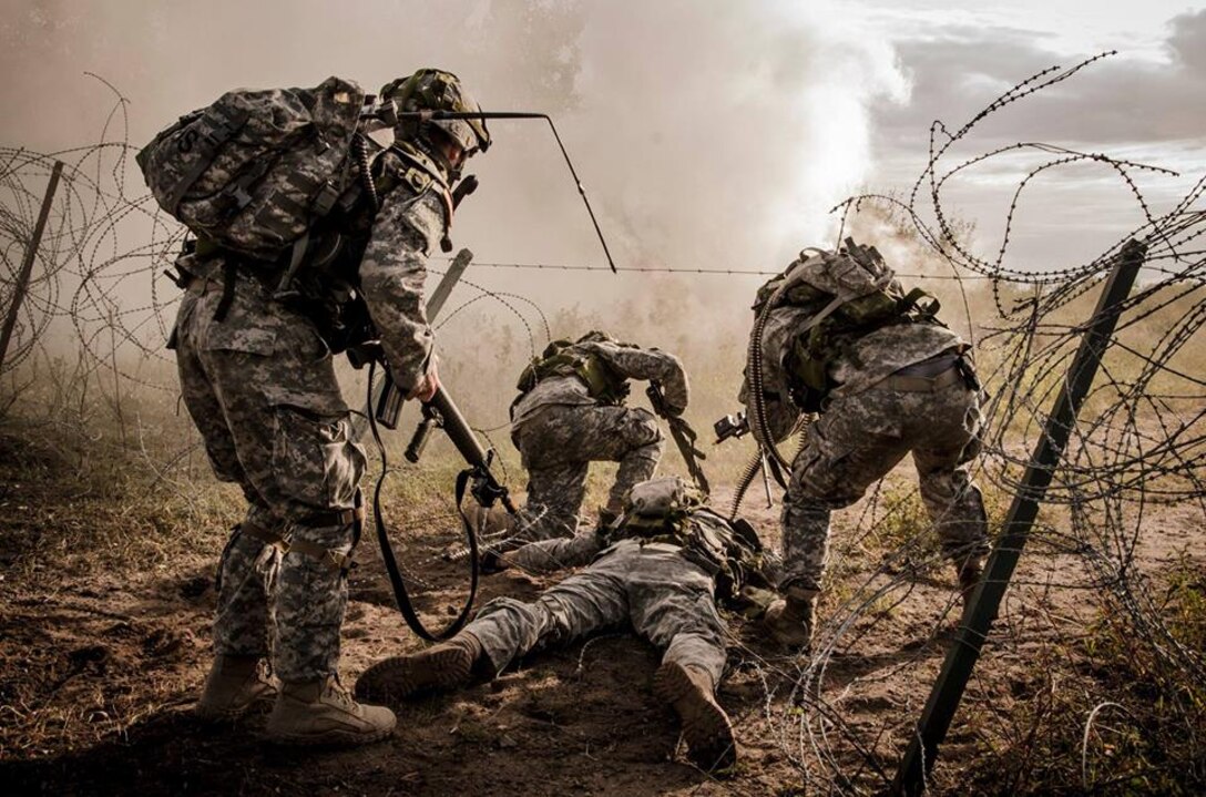 A U.S. soldier uses his body to create an opening in a wire obstacle so his team can assault a position during Exercise Grizzly Defender in Alberta, Aug. 21, 2015. Grizzly Defender is a joint training exercise with the Canadian Army Reserve that focuses on offensive tasks including patrols, convoys, raids, information operations, traffic control points and company-level group attacks. The soldiers are members of the Washington National Guard. Washington National Guard photo by Army Sgt. Matthew Sissel
