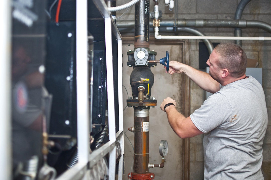 Cutline
Christian French, Facilities Maintenance Section HVAC technician, maintains the cooling and heating systems at Lejune Hall, Sept. 8. The post organizations will prepare standardized switchovers to discontinue the cooling system in older buildings Oct. 1 in preparation for the Fall 2015. French has worked as a technician aboard Marine Corps Base Quantico for more than five years. 
