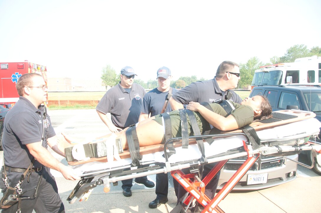 Second Lt. Katrina Herrera, a student of The Basic School, is transported to an emergency vehicle during a water-rescue emergency simulation training at the Ramer Hall Gymnasium, Aug. 4. Firemen from the Quantico Fire Station 533 at The Basic School helped to reinforce training by coordinating and annual simulation with the Marine Corps Instructor Trainer of Water Survival team.