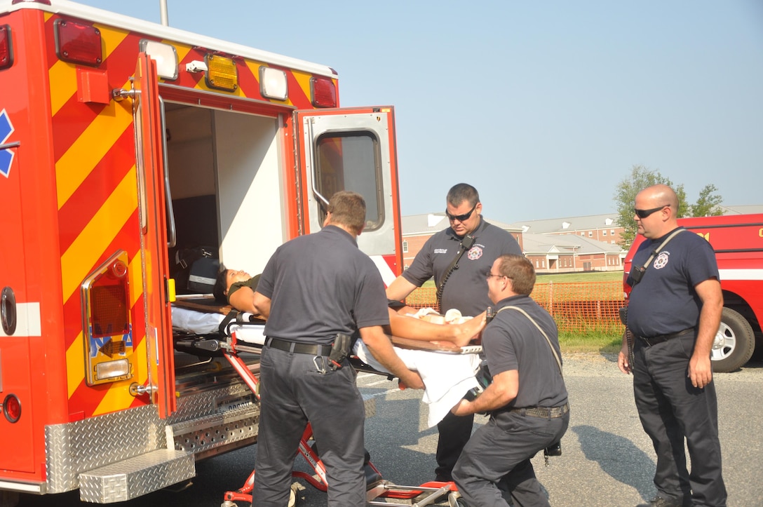 Firemen from the Quantico Fire Station 533 at The Basic School transmit a TBS student during a water-rescue emergency simulation training at the Ramer Hall Gymnasium, Aug. 4.