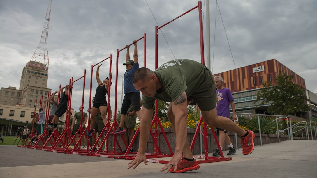 Gunnery Sgt. Orlando Flamenco a member of a combat logistic regiment at Marine Corps Base Camp Pendleton, California, drops down to do a burpee during a physical training event at Civic Space Park on Sept. 9, 2015, as part of Marine Week Phoenix.  The event allows members of the community to join in and conduct the exercises alongside the Marines.