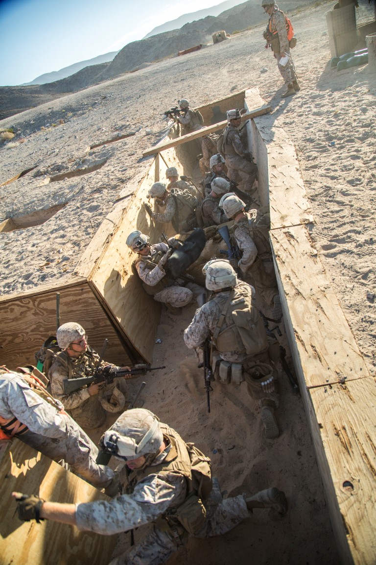 Marines with Company “G”, 2nd Battalion, 1st Marine Regiment, regroup and provide suppression fire in a fighting trench during a live fire platoon attack mission during Realistic Urban Training Exercise (RUTEX) at range 410 Alpha aboard Marine Corps Air Ground Combat Center Twentynine Palms, Calif., Sept. 1, 2015. RUTEX provides Marines and Sailors of the 13th Marine Expeditionary Unit (13th MEU) an opportunity to perform and practice their duties while deployed in an urban environment. (U.S. Marine Corps photo by Sgt Hector de Jesus/Released)