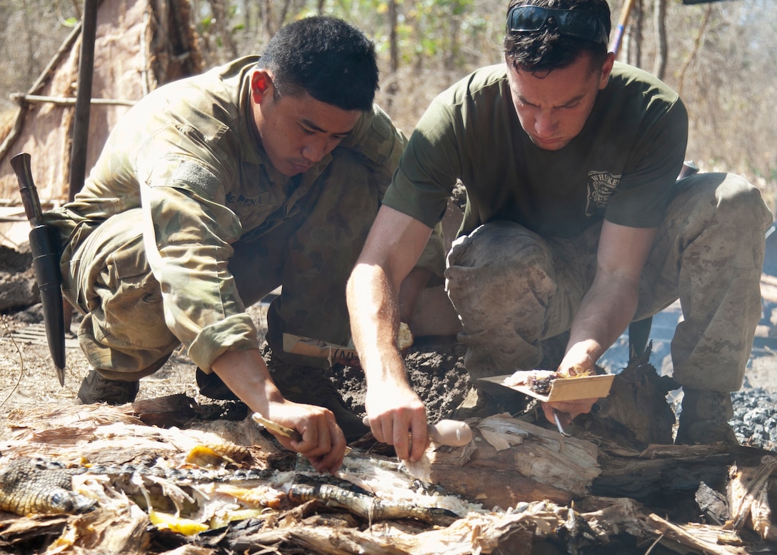 Australian Army LCPL Michael Dela Pena, left, and U.S. Marine Corps Lance Cpl. Tylor Lea with 1st Battalion, 4th Marine Regiment, Marine Rotational Force - Darwin, a Eugene, Oregon native, gather crocodile meat during Exercise Kowari 15 Sept. 4 in the Daly River region, Northern Territory, Australia. Kowari is a trilateral environmental survival training opportunity hosted by Australia and includes forces from Australia, China and the U.S. simultaneously. 