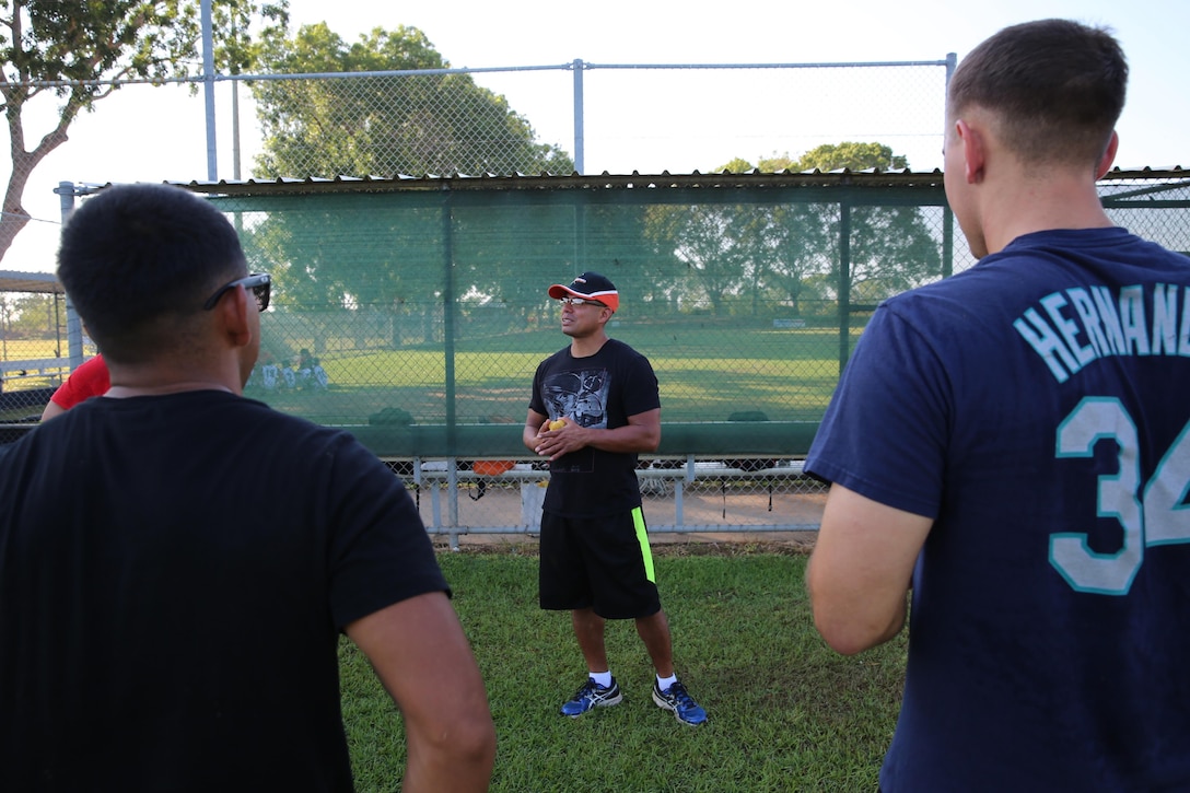 U.S. Marine Corps Gunnery Sgt. Pedro Chamorro, a supply chief with Marine Heavy Helicopter Squadron 463, Marine Rotational Force – Darwin and a native of Miami, discusses teamwork with Marines during a softball clinic for local youth July 25 at Tracy Village Social and Sports Club, Wanguri, Northern Territory, Australia. The Marines supported the U.S. State Department-sponsored community event with the Northern Territory’s school softball program to mentor the students and teach them how to play competitively. Beyond purely military training, Marines’ involvement in community engagements in the Northern Territory shows their appreciation for Australia’s hospitality. 