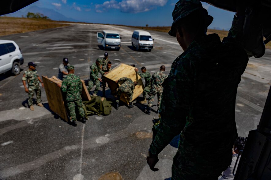 A soldier with the Falintil Forças de Defesa de Timor-Leste watches from a truckbed as U.S. Airmen and Timorese service members work to open and remove airdropped pallet boxes Sept. 8, 2015, in Baucau, Timor-Leste. The packages contained rice and were airdropped by a North Carolina Air National Guard C-130 Hercules crew during Operation Pacific Angel 15-2. Efforts undertaken during Pacific Angel help multilateral militaries in the Pacific improve and build relationships across a wide spectrum of civic operations, which bolsters each nation’s capacity to respond and support future humanitarian assistance and disaster relief operations. (U.S. Air Force photo by Staff Sgt. Alexander W. Riedel/Released)