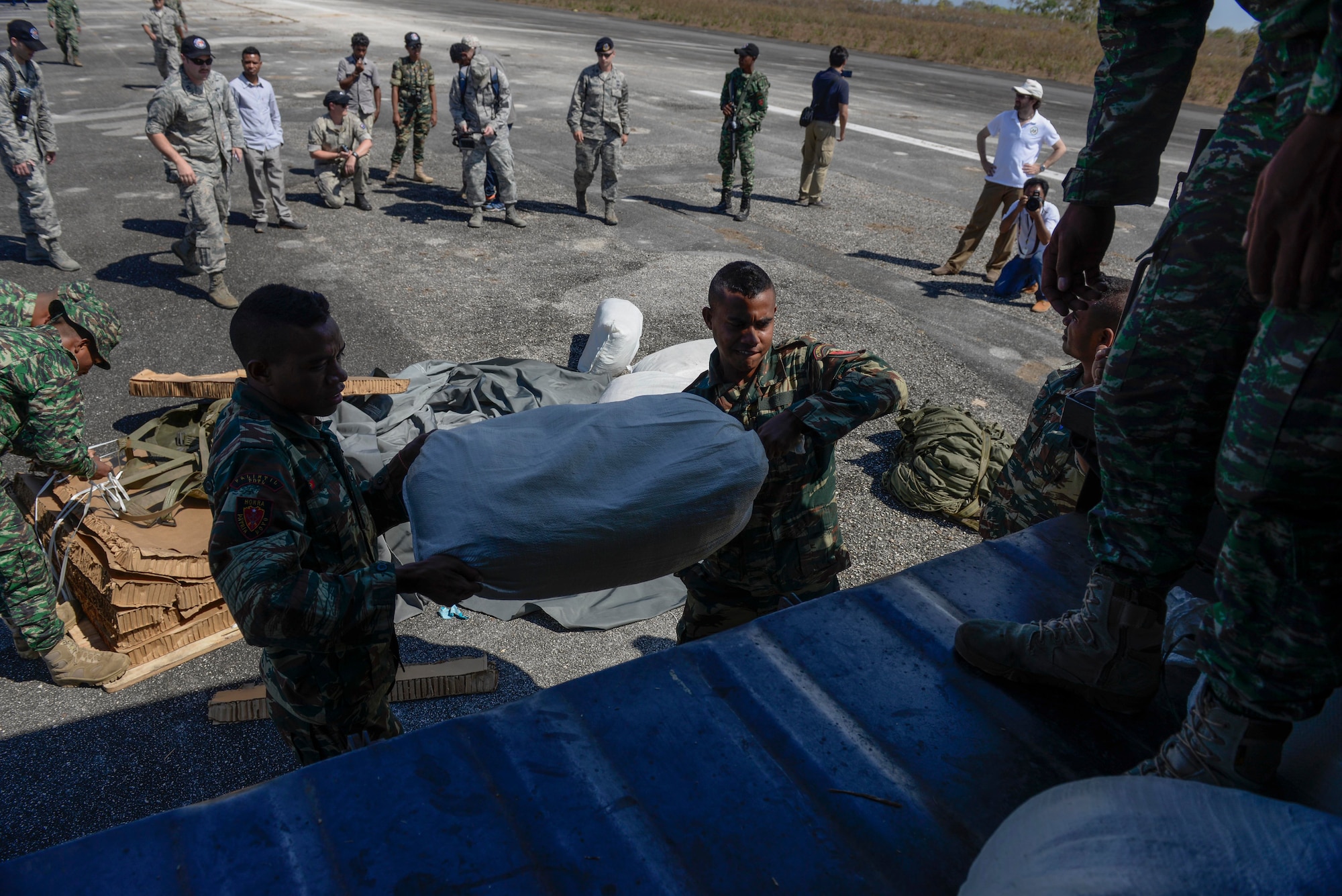 Soldiers with the Falintil Forças de Defesa de Timor-Leste load bags of rice that were just airdropped by a U.S. Air Force C-130 Hercules over Baucau airfield, Sept. 8, 2015, in Baucau, Timor-Leste. The packages were airdropped by a North Carolina Air National Guard C-130 crew during Operation Pacific Angel 15-2. Efforts undertaken during Pacific Angel help multilateral militaries in the Pacific improve and build relationships across a wide spectrum of civic operations, which bolsters each nation’s capacity to respond and support future humanitarian assistance and disaster relief operations. (U.S. Air Force photo by Staff Sgt. Alexander W. Riedel/Released)