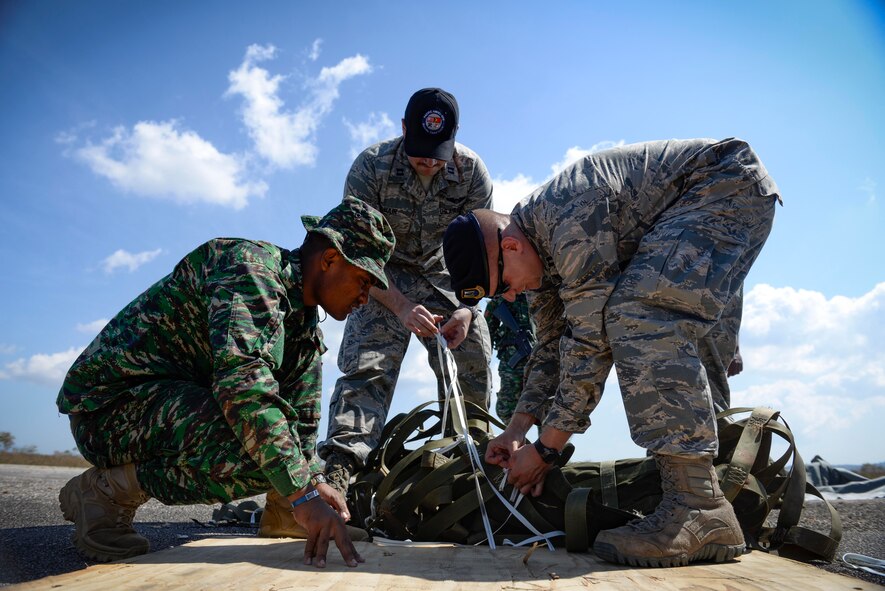 U.S. Air Force Captains Jay Bateman, 736th Security Forces Squadron director of operations, right, and Christopher Baird,  621st Mobility Support Operations Squadron air mobility liaison, untangle airdrop rigging with the help of a Falintil Forças de Defesa de Timor-Leste soldier Sept. 8, 2015, in Baucau, Timor-Leste. The rigging material contained rice packages that were airdropped by a North Carolina Air National Guard C-130 Hercules during Operation Pacific Angel 15-2. Efforts undertaken during Pacific Angel help multilateral militaries in the Pacific improve and build relationships across a wide spectrum of civic operations, which bolsters each nation’s capacity to respond and support future humanitarian assistance and disaster relief operations. (U.S. Air Force photo by Staff Sgt. Alexander W. Riedel/Released)