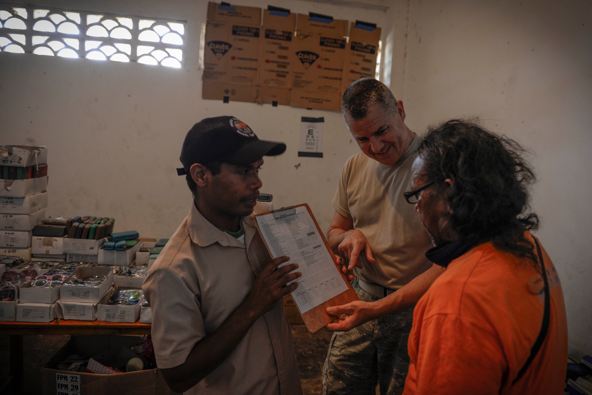 U.S. Air Force Master Sgt. Robert Shaw (center), 141st Medical Group NCO in charge of optometry, shows a patient his vision results during an Operation Pacific Angel health services outreach event Sept. 7, 2015, in Baucau, Timor-Leste. Pacific Angel is a multilateral humanitarian assistance civil military operation, which improves military-to-military partnerships in the Pacific while also providing medical health outreach, civic engineering projects and subject matter exchanges among partner forces. (U.S. Air Force photo by Staff Sgt. Alexander W. Riedel/Released)