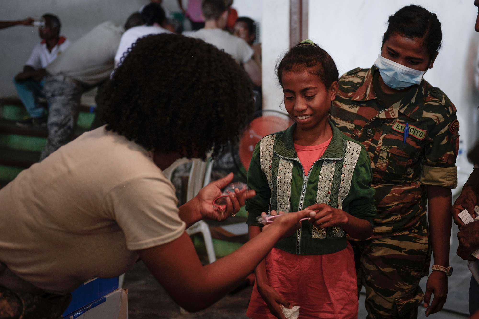 U.S. Air Force Staff Sgt. Latrisha Skinner (left), 35th Aerospace Medicine Squadron optometry technician, offers a choice of sunglasses to a young patient following her optometry examination during an Operation Pacific Angel 15-2 health services outreach event Sept. 7, 2015, in Baucau, Timor-Leste. Pacific Angel is a multilateral humanitarian assistance civil military operation, which improves military-to-military partnerships in the Pacific while also providing medical health outreach, civic engineering projects and subject matter exchanges among partner forces. (U.S. Air Force photo by Staff Sgt. Alexander W. Riedel/Released)