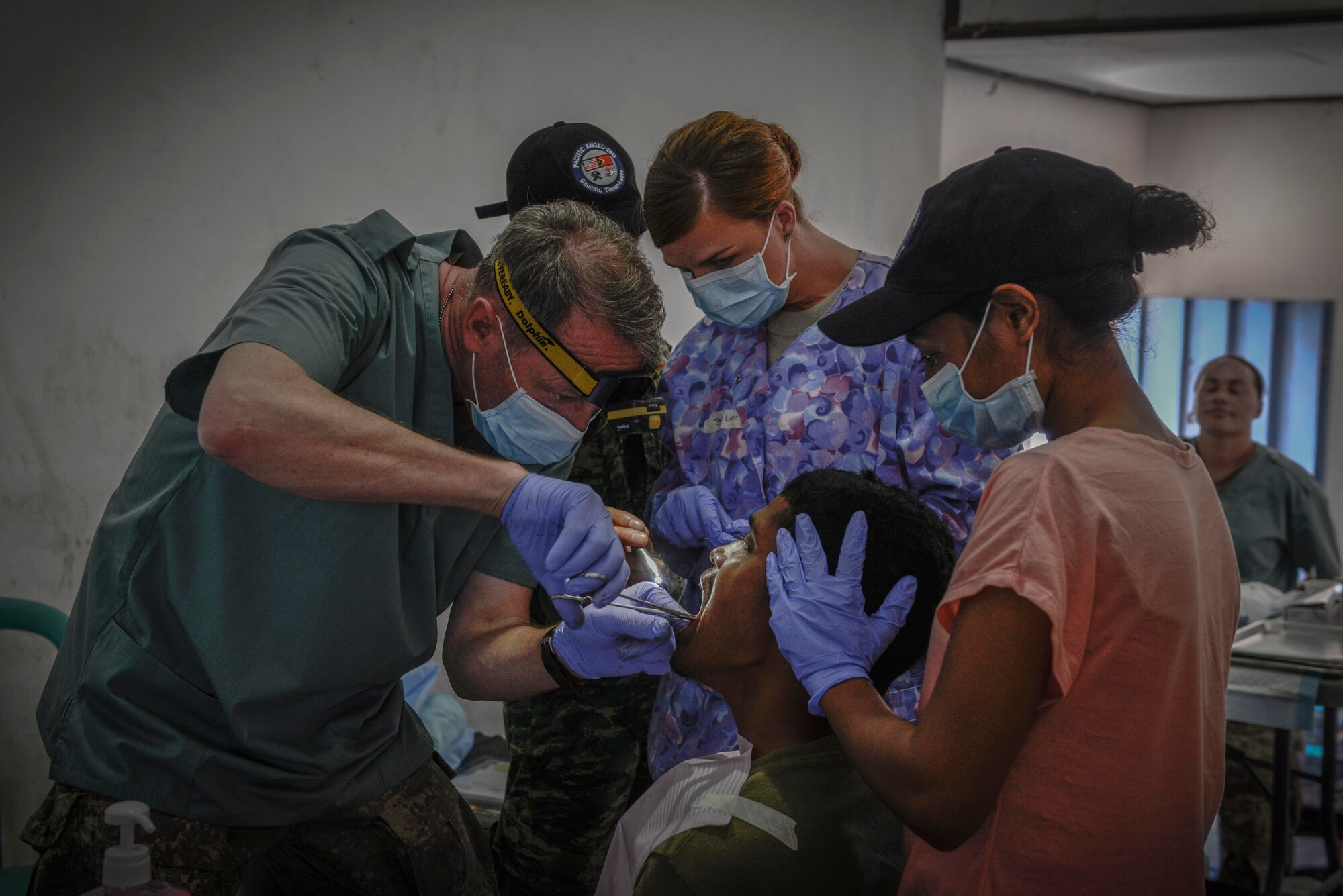 New Zealand Defense Force Maj. Phil Worthington, northern region dental commander, extracts a tooth with the help of U.S. Air Force and Timorese service members during an Operation Pacific Angel 15-2 health services outreach event Sept. 7, 2015, in Baucau, Timor-Leste. Pacific Angel is a multilateral humanitarian assistance civil military operation, which improves military-to-military partnerships in the Pacific while also providing medical health outreach, civic engineering projects and subject matter exchanges among partner forces. (U.S. Air Force photo by Staff Sgt. Alexander W. Riedel/Released)