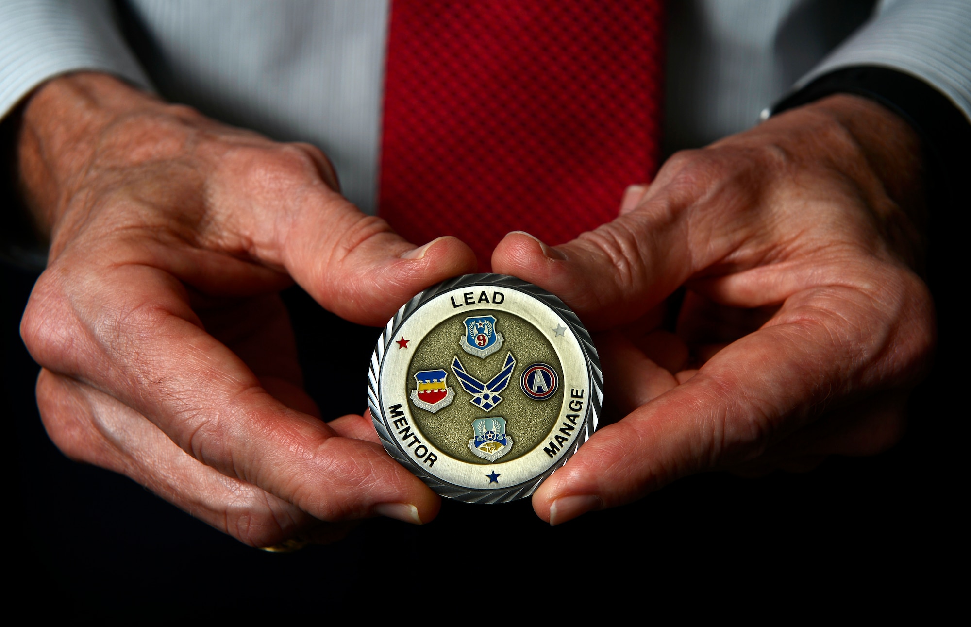Former U.S. Air Force Capt. Joseph McElveen holds a coin given to him by the Shaw Top Three in Sumter, S.C., Aug. 25, 2015. McElveen has collected over 30 coins since separating from the Air Force and becoming city mayor of Sumter, S.C. (U.S. Air Force photo by Senior Airman Jensen Stidham/Released)