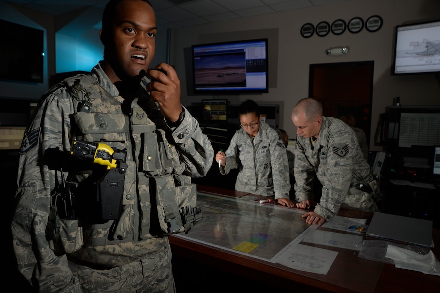 Staff Sgt. Kevin Singleton, 799th Security Forces Squadron flight sergeant, answers a base defense operations center radio call at Creech Air Force Base, Nevada, Sept. 2, 2015. The BDOC is the heart of all security forces operations supporting the remotely piloted aircraft enterprise at Creech.  (U.S. Air Force photo by Tech. Sgt. Nadine Barclay) 