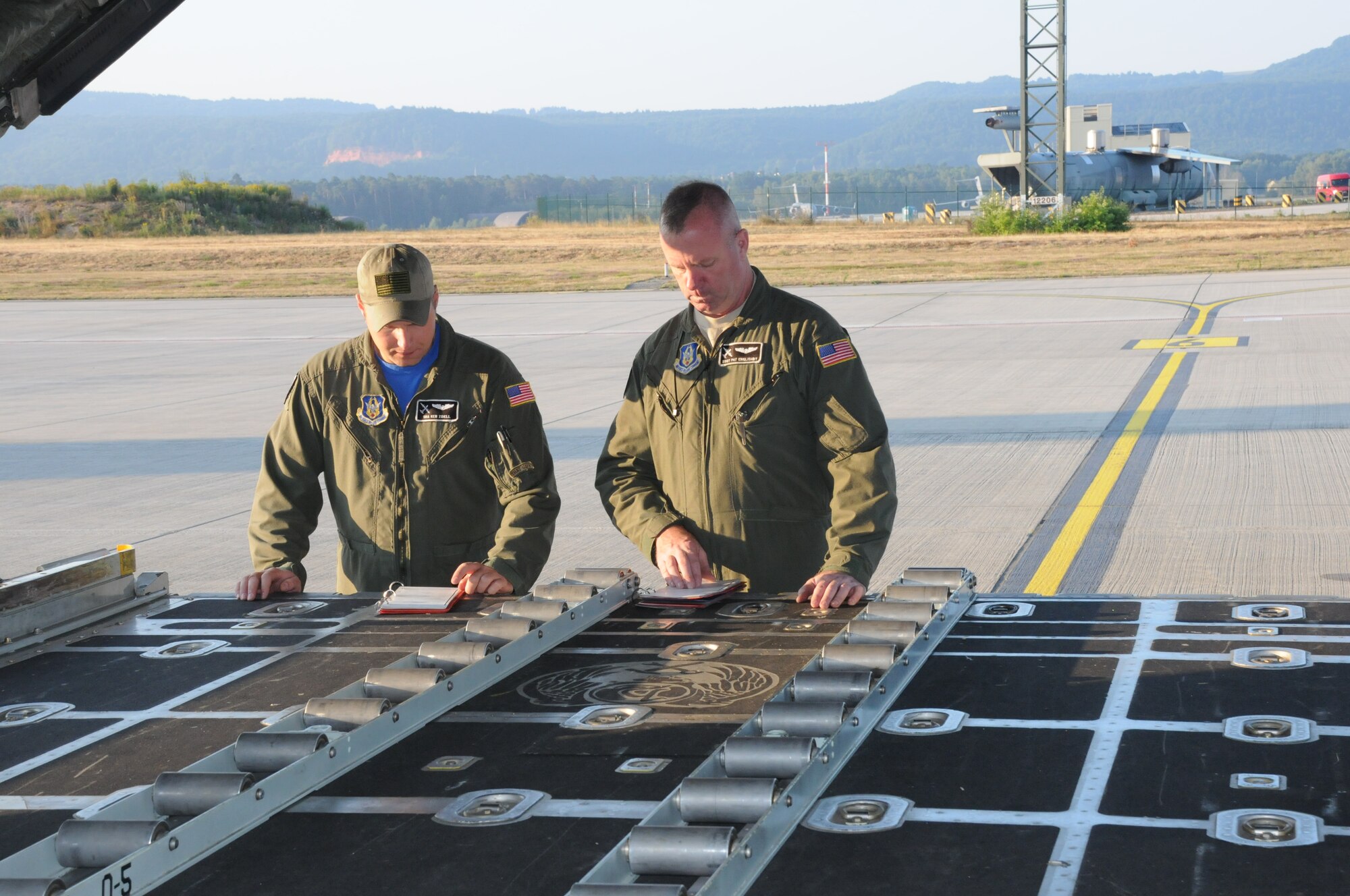 Staff Sgt. Pat Englishby and Senior Airman Ken Zidell, loadmasters, 328th Airlift Squadron, review checklist procedures inside a C-130 Hercules aircraft at Ramstein Air Base, Germany, on Aug. 21, 2015. Englishby and Zidell were preparing for Exercise Swift Response, a multinational training exercise that focused on airdrops. (U.S. Air Force photo by Staff Sgt. Matthew Burke/released)
