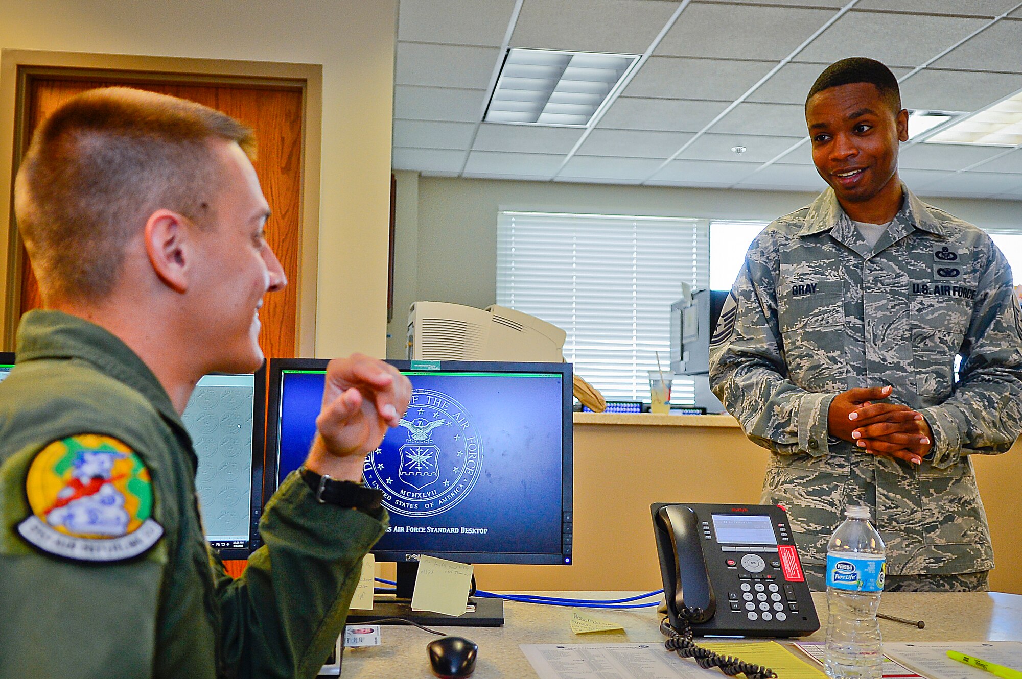 Master Sgt. Patrick Gray, 91st Air Refueling Squadron NCO in charge of aviation resource management, talks to Staff Sgt. Darren Clever, 91st ARS NCO in charge of scheduling, at MacDill Air Force Base, Fla., Sept. 3, 2015. Gray maintains flight records and monitors flying hours for aircrew and aircraft. (U.S. Air Force photo by Senior Airman Ned T. Johnston/Released)