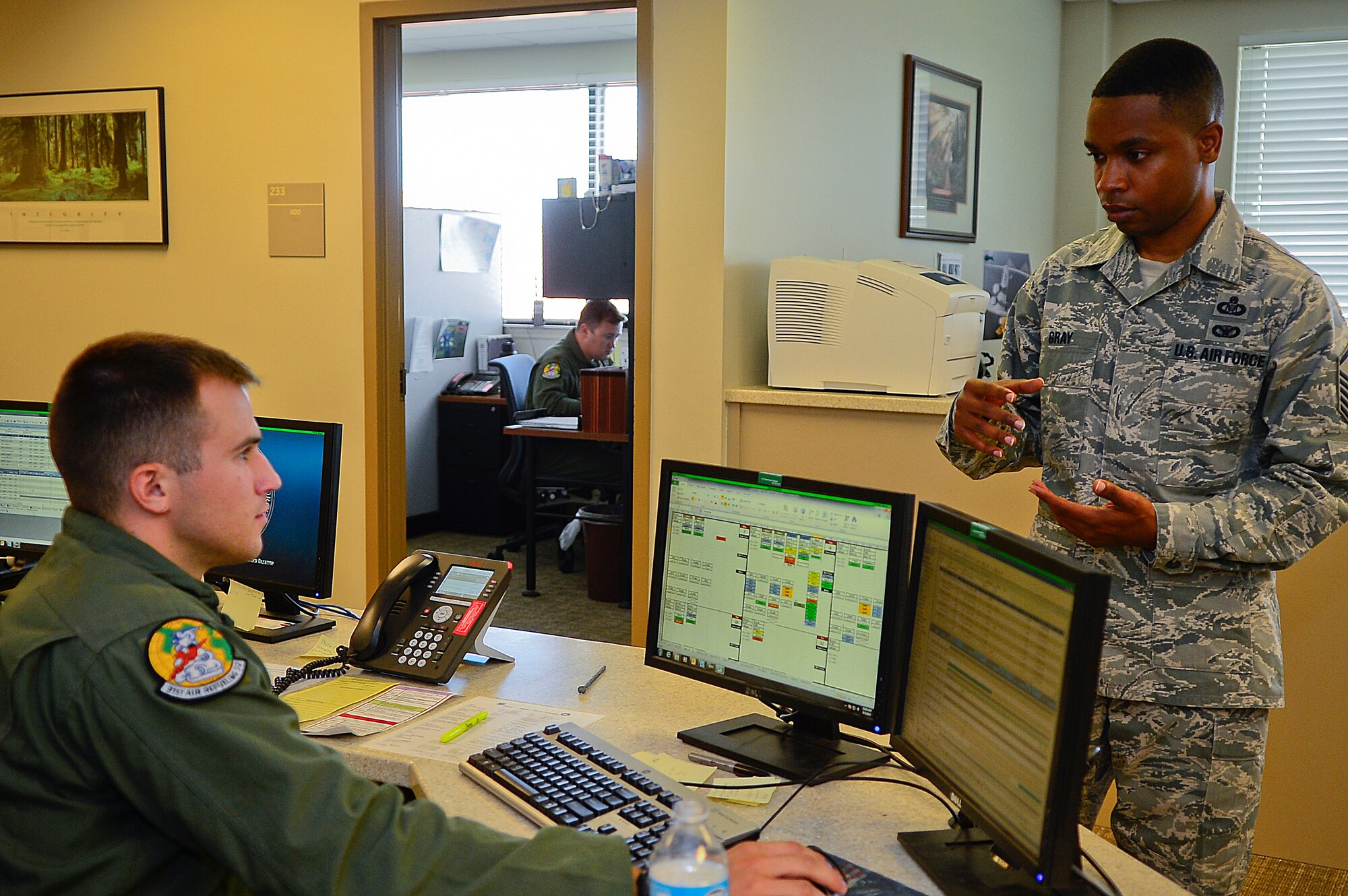 Master Sgt. Patrick Gray, 91st Air Refueling Squadron NCO in charge of aviation resource management, discusses scheduling issues with one of his Airmen at MacDill Air Force Base, Fla., Sept. 3, 2015. Gray maintains daily flight mission data to indicate the takeoff, in-flight and landing status of each flight. (U.S. Air Force photo by Senior Airman Ned T. Johnston/Released)